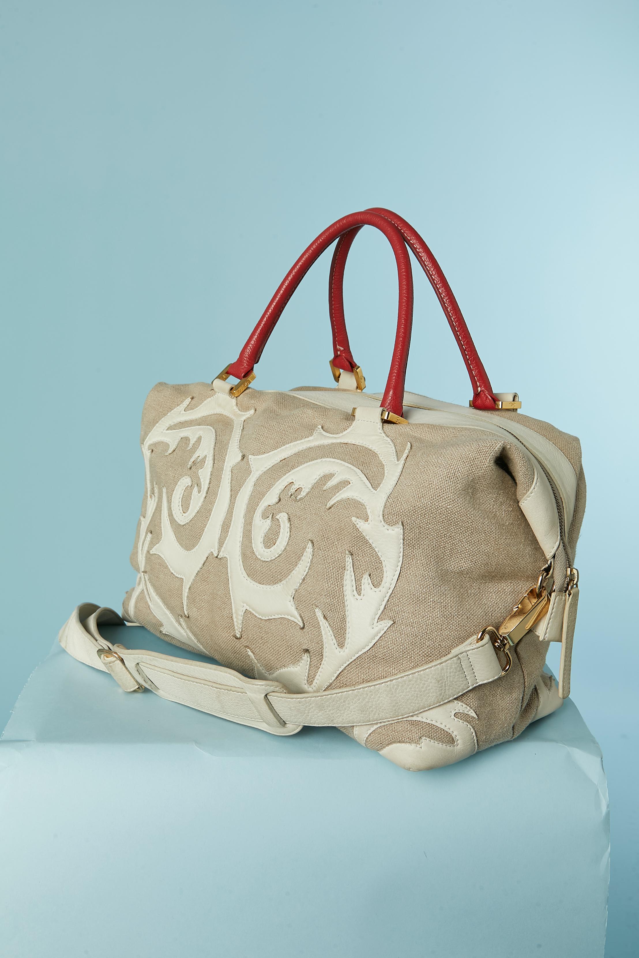 Linen canevas and leather appliqué large top handle bag. Branded nylon lining. Zip closure on the top front + snaps on both edge. 2 inside pocket with zip and 2 flat pocket. Gold metal studs underneath.
SIZE : 37cm X 30cm X 15 cm 
Top handle lenght