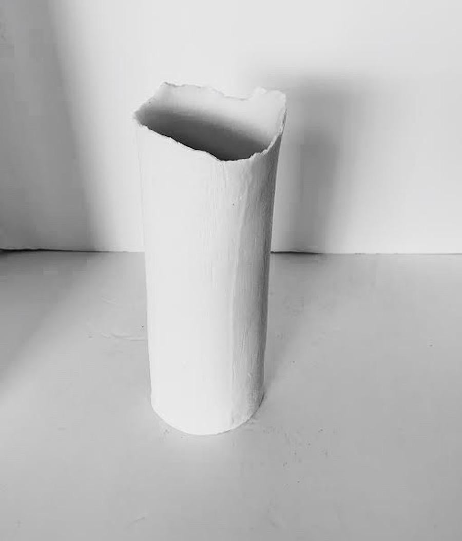 Contemporary French handmade white fine ceramic cylinder shaped vase is a one of a kind piece.
The vase is fine ceramic with a textured surface that looks like linen.
The mouth of the vase has an unfinished rough edge detail.
A collection of five