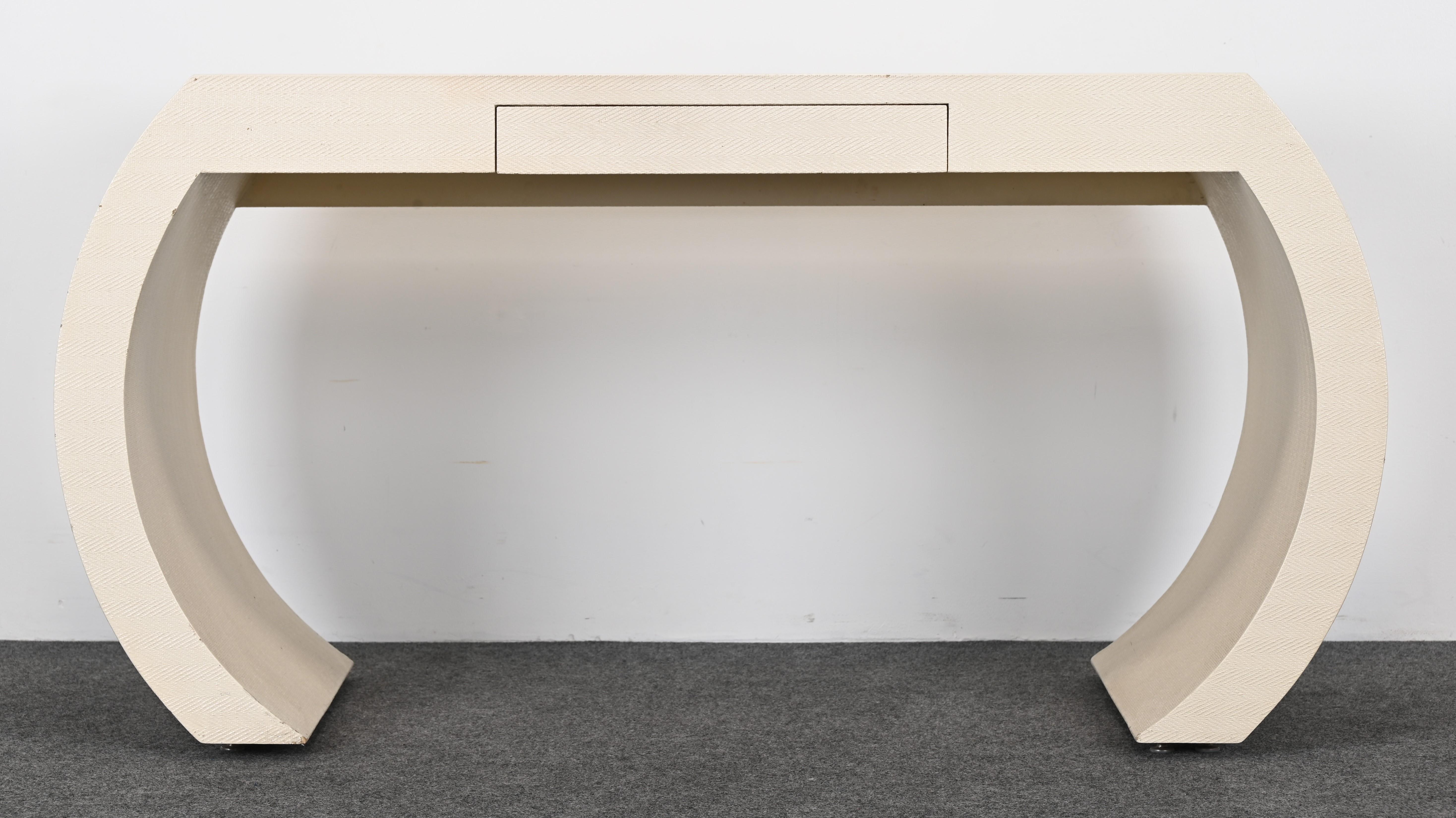 A chic lacquered linen-covered scroll desk with one drawer. This beautiful ivory Karl Springer-style simple line desk would look great in any interior. It would work well with Mid-Century Modern as well as Traditional. The desk is structurally sound