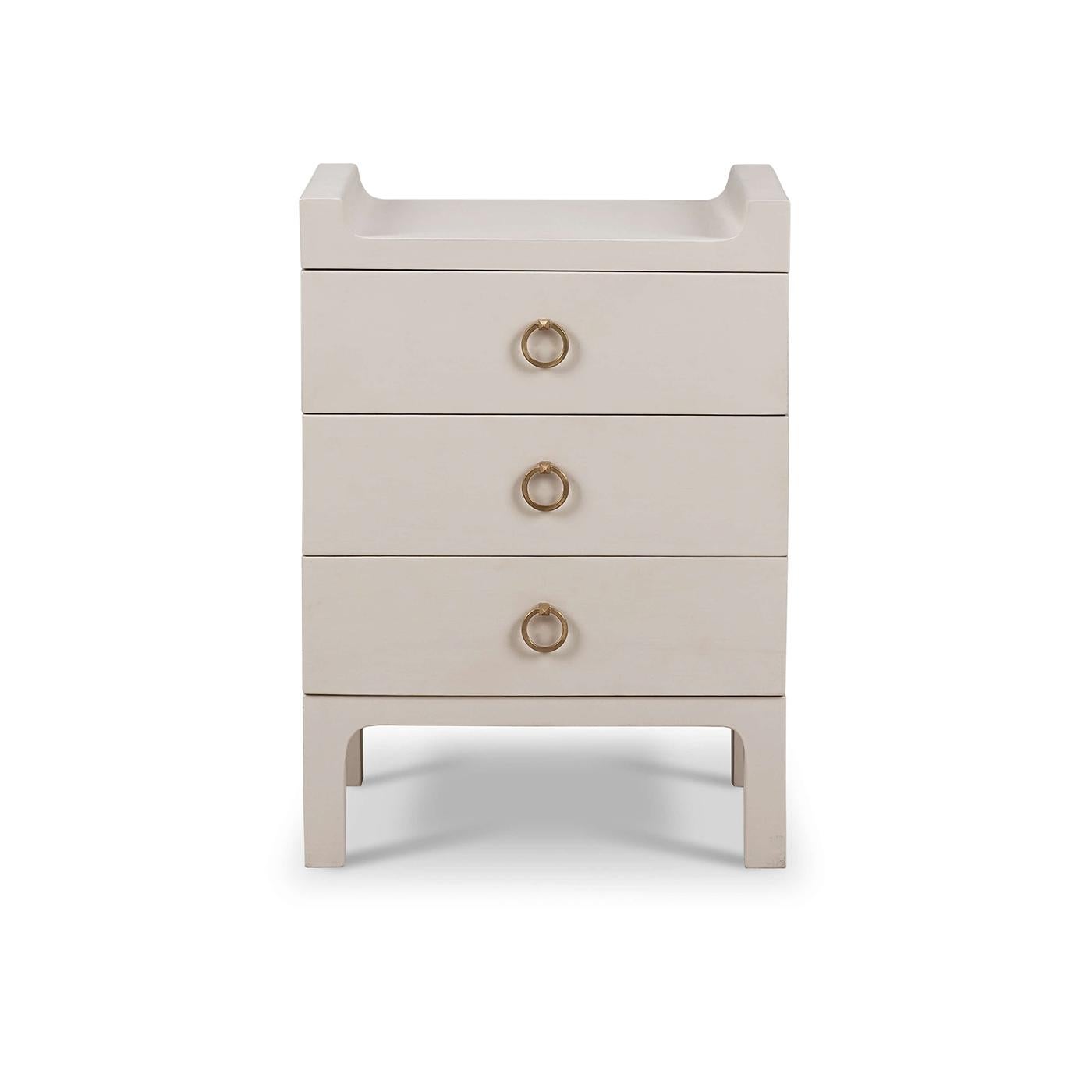 Crafted with a minimalist design, this stand features clean lines and a chic, putty-colored linen wrap that perfectly captures the essence of Scandinavian style. The three drawers, adorned with brass handles, provide ample storage for your bedside