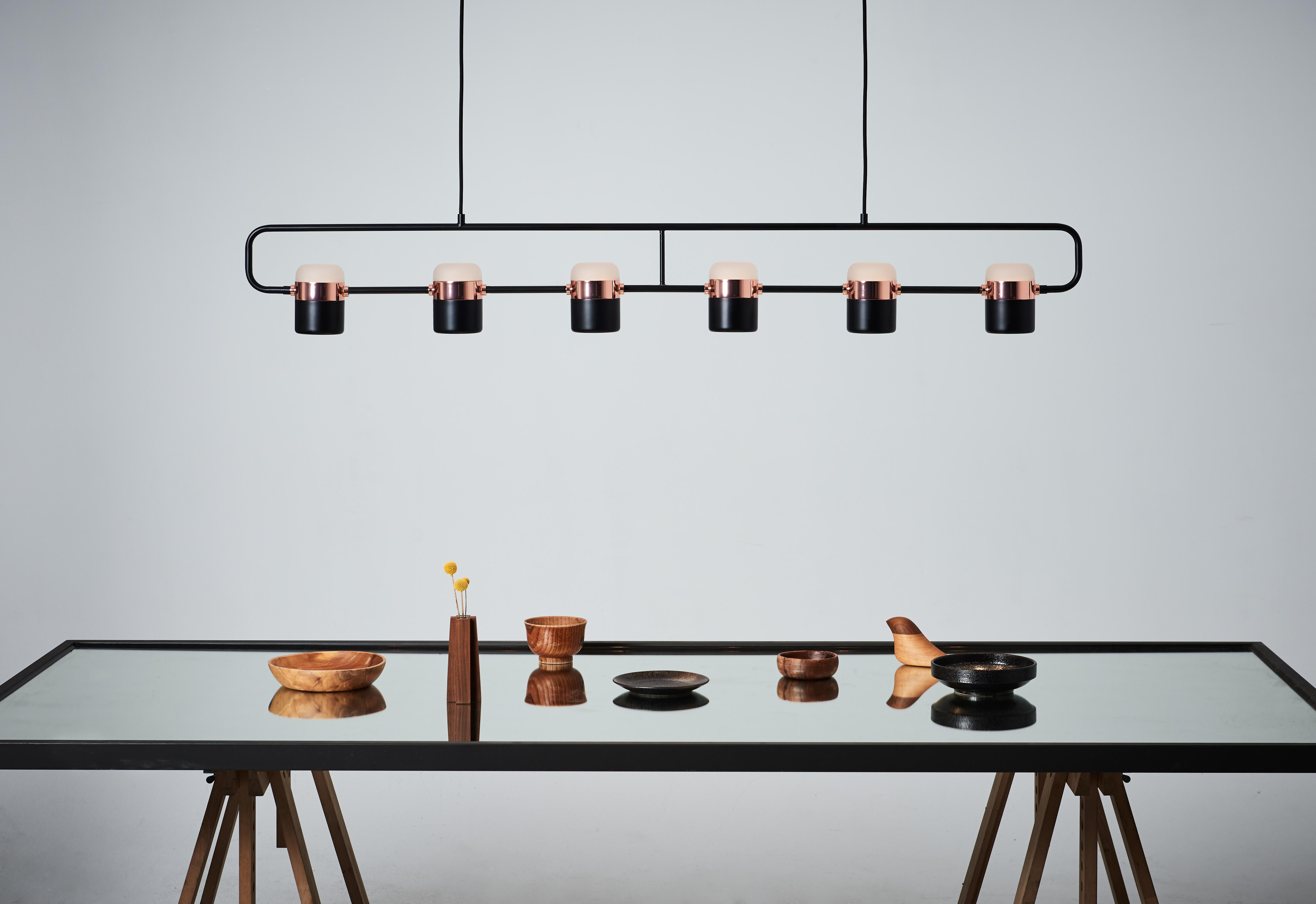 LING Pendant 6 is a harmonious mingle of minimalism and nostalgia design which is inspired by patterned metal-fence used to be built around balconies and windows in early Taiwan. The copper/ brass glow elegantly connects glass and metal shade.
