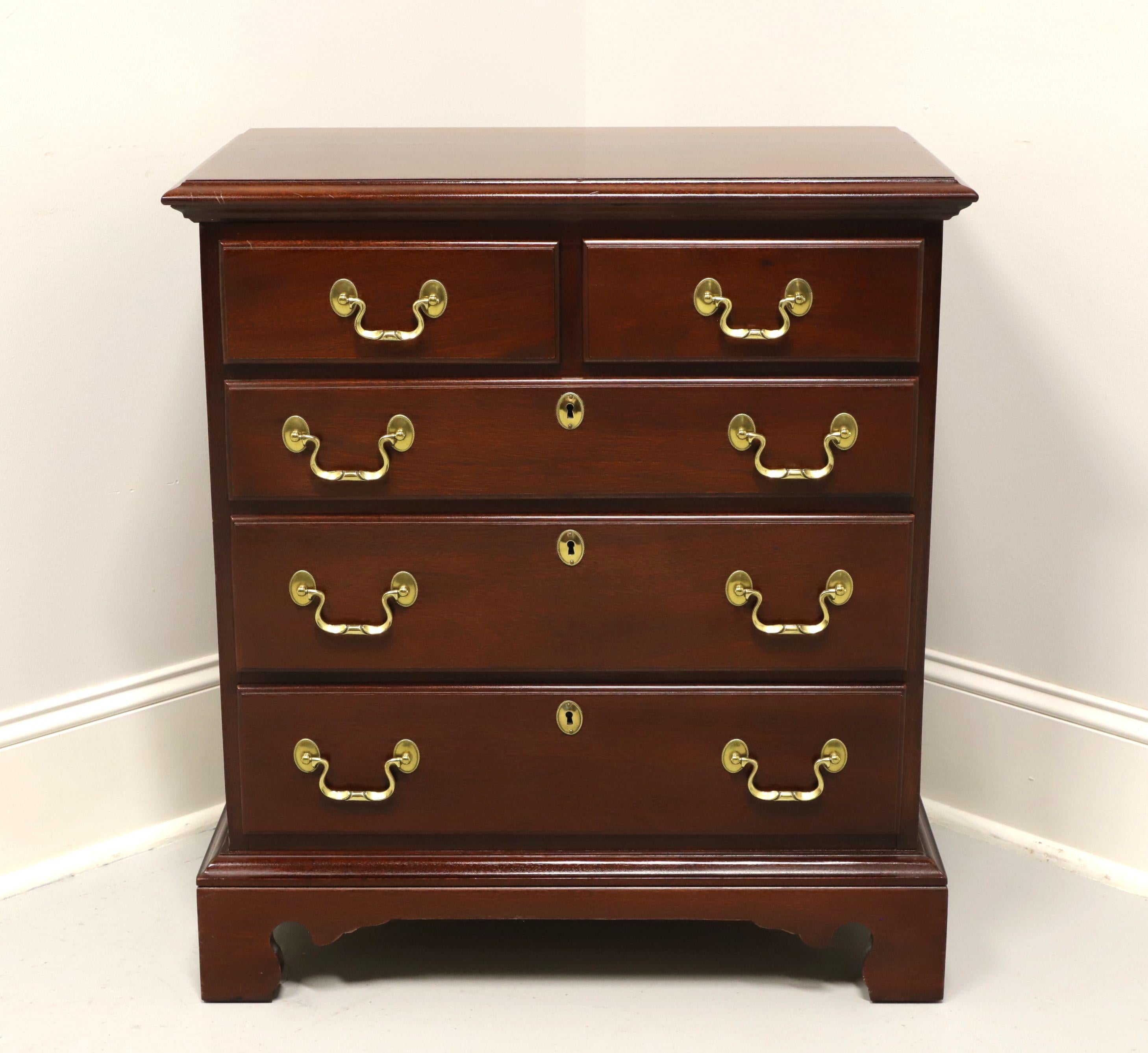 A Chippendale style bedside chest by Link-Taylor. Solid mahogany with brass hardware, brass side handles and bracket feet. Features two over three drawers of dovetail construction, three lower with faux keyhole escutcheons. Made in Lexington, North