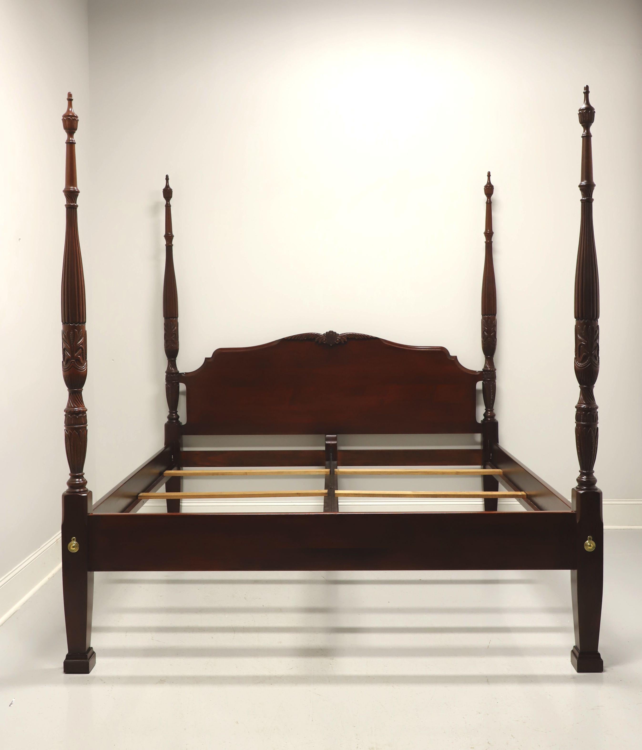 A Chippendale style king size rice carved poster bed by Link-Taylor. Solid heirloom mahogany with decoratively carved arched headboard, four rice carved posts with finials, brass hardware, bolt held side rails with wood bracers, center metal rail