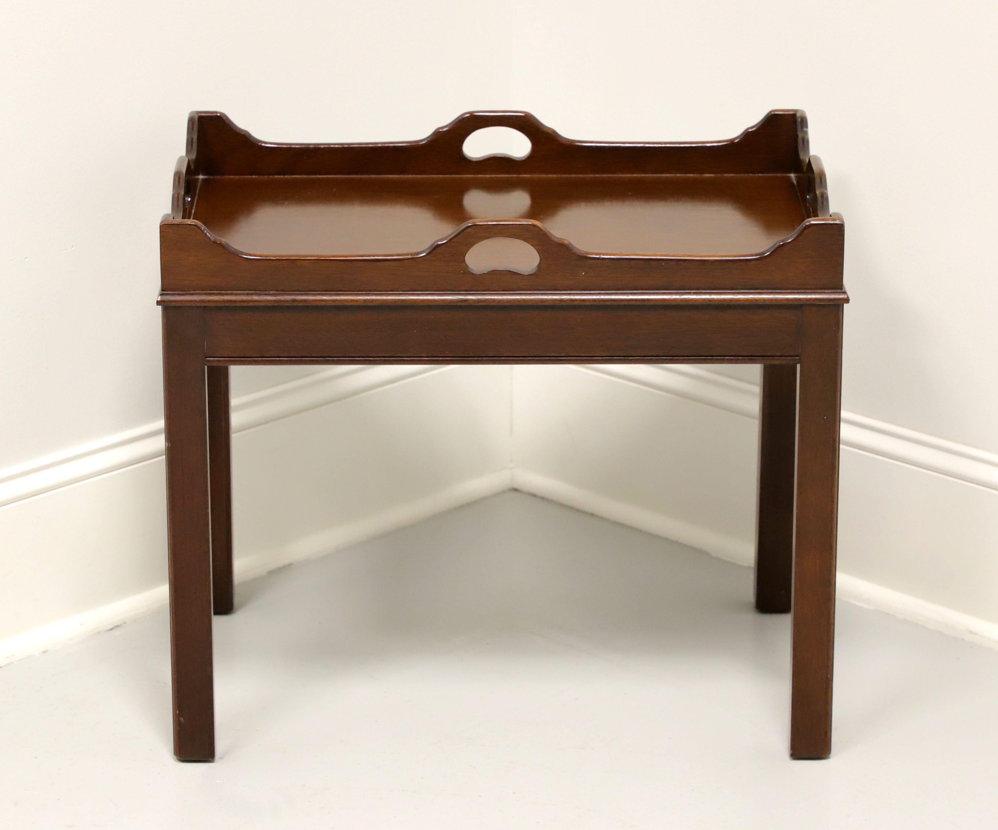 A Chippendale style tea table by Link-Taylor, from their Heirloom Gallery. Solid mahogany with a butlers tray like top with carved open handles, two slide out trays with brass pulls and straight legs. Made in Lexington, North Carolina, USA, in the