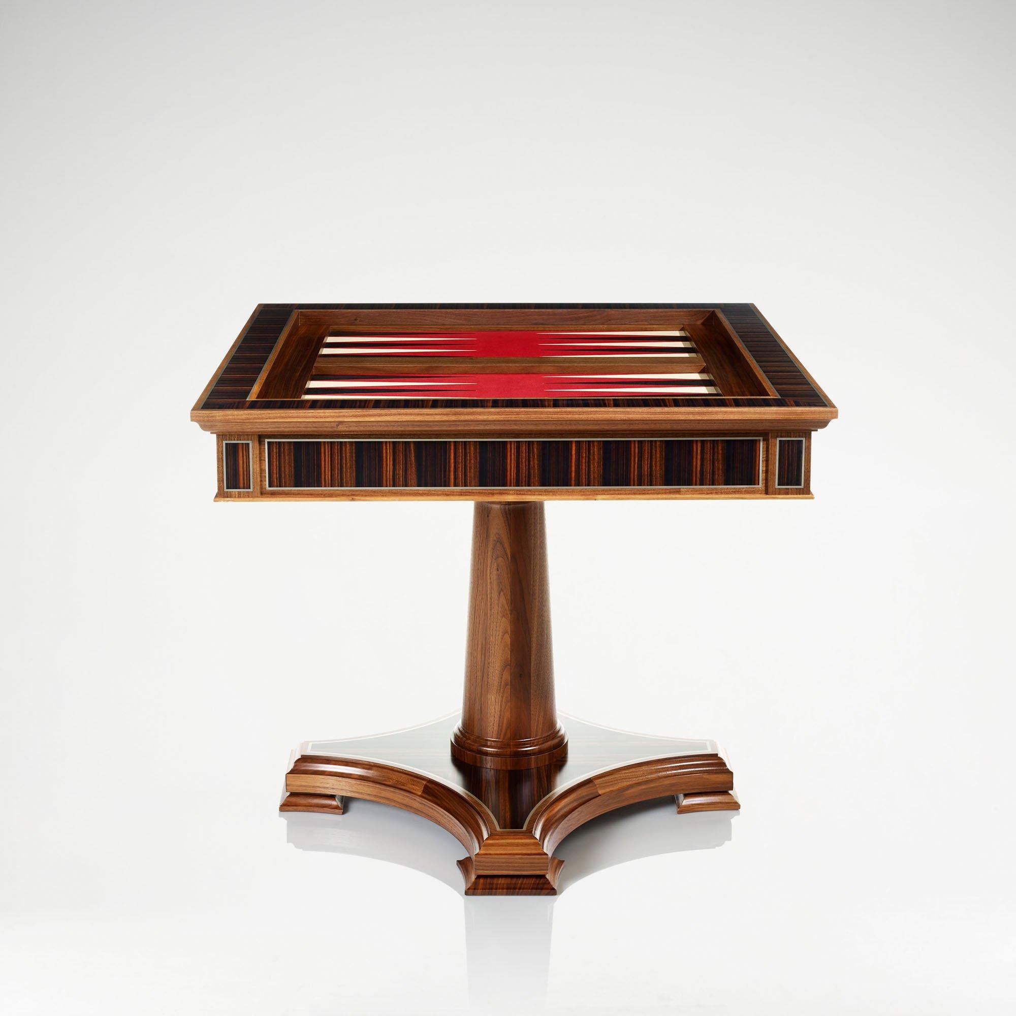 An elegant and classical games table in walnut, equipped for chess, cards, backgammon, dominoes and bridge.

The table is made from walnut with inlays of Macassar ebony, and aluminum and ebony stringing’s. The top features a reversible chess board