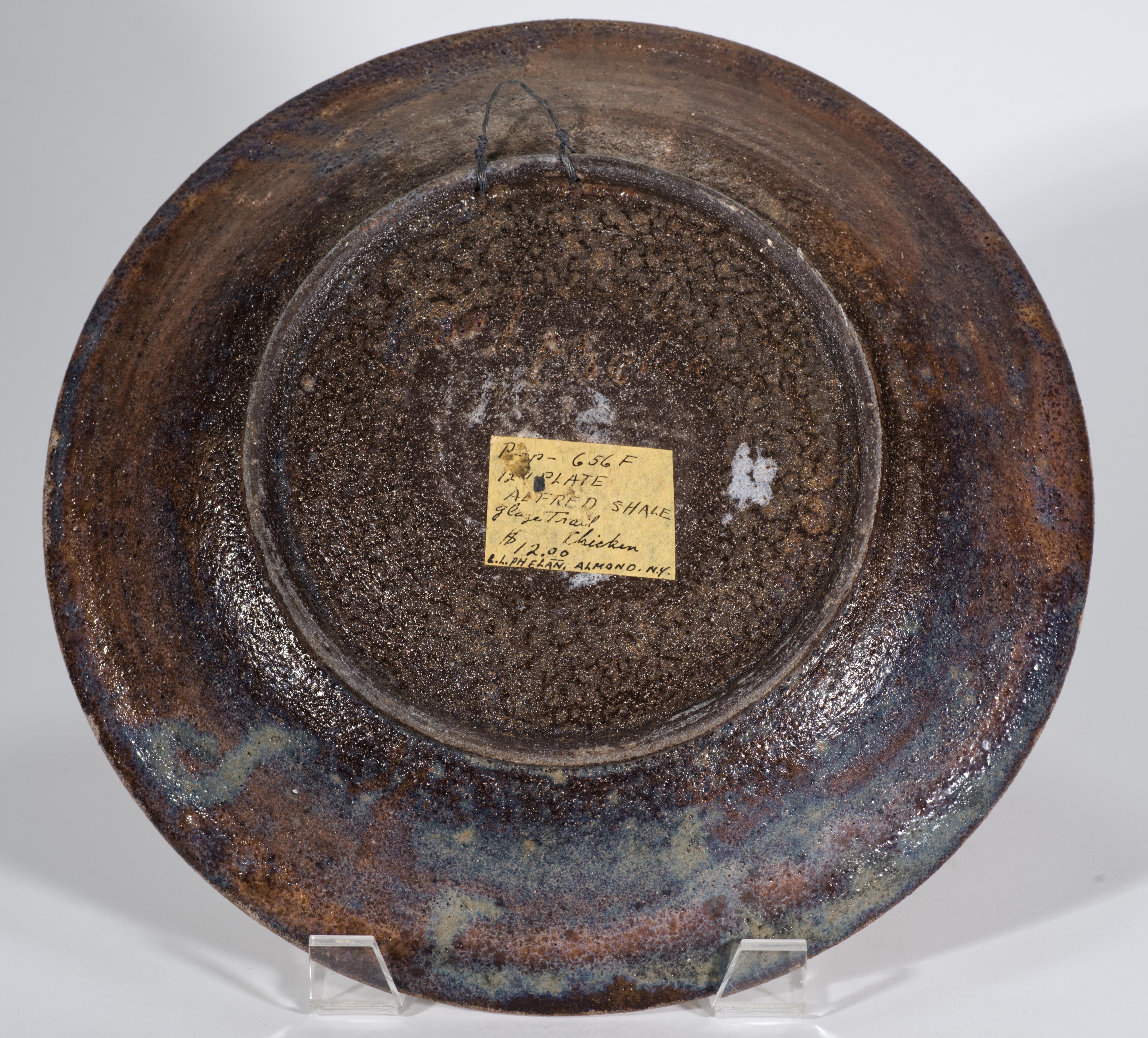  Vintage ceramic decorative plate or bowl features a playful Modernist design of a chicken, hand-painted in off-white textured lava glaze on mocha and espresso brown drip glaze background. The rim of the plate is accented with the lava glaze border