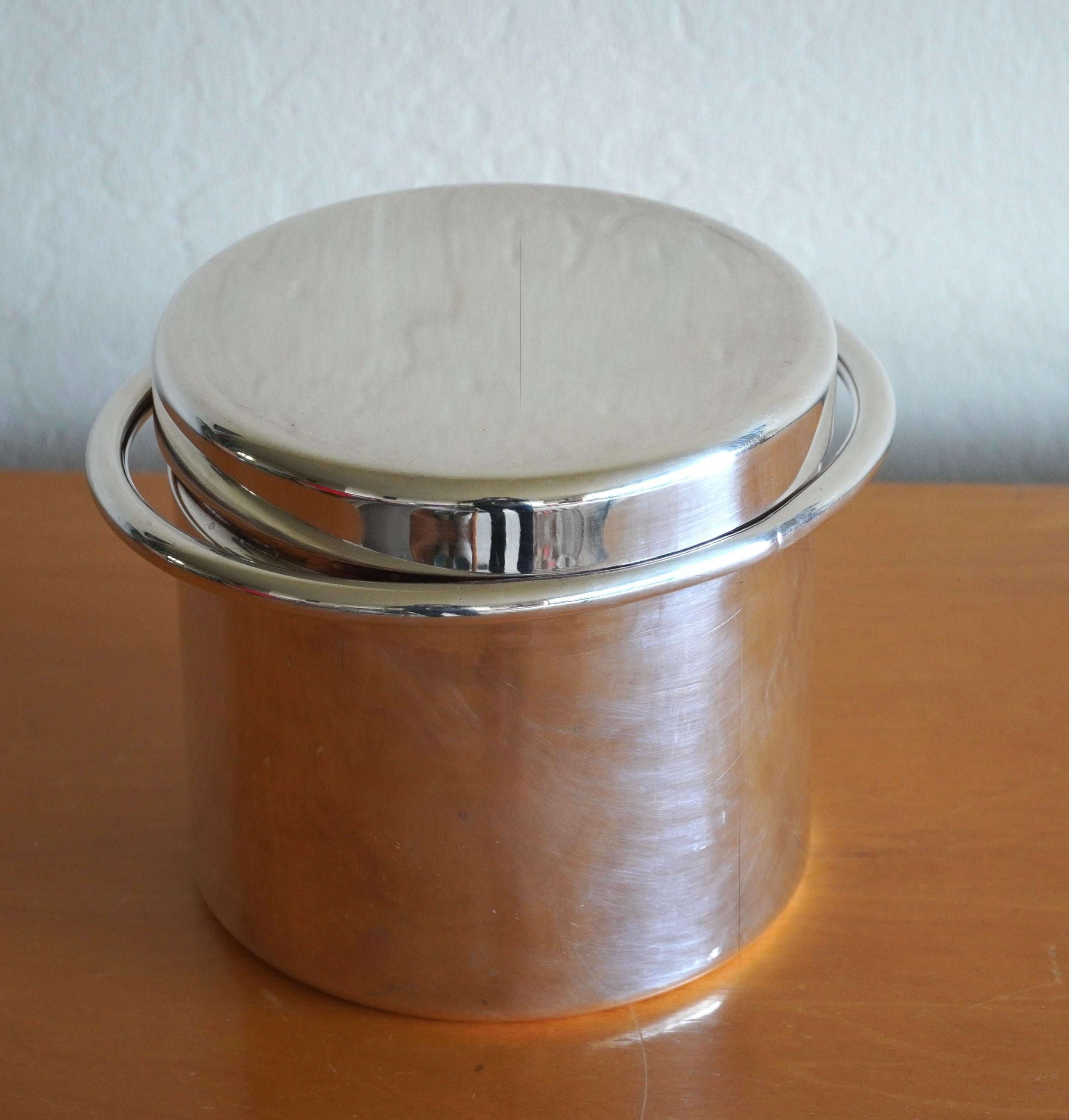 Ice bucket by Italian Industrial Designer Lino Sabattini (1926-2016). A cylindrical form with an elliptical handle near the top at the bottom of the lid creating a very elegant yet simple design. Stamped on the bottom Sabattini, Made in Italy.