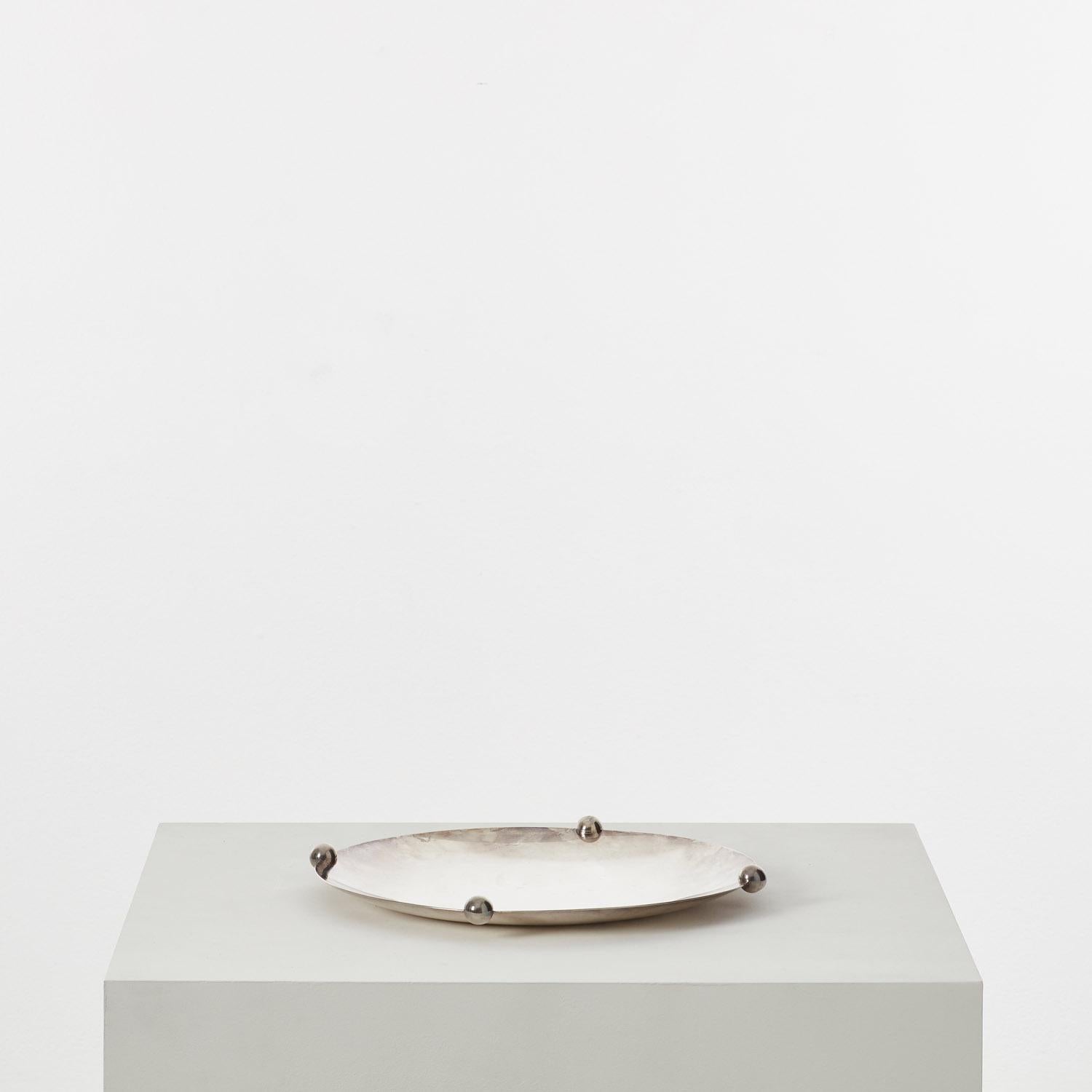 A silver-plated brass dish by pioneering Italian silversmith Lino Sabattini (1925-2016). Four polished silver spheres intersect the slim rim with a signature purity of form.

“I find that the workshop is often better than a school, because there is