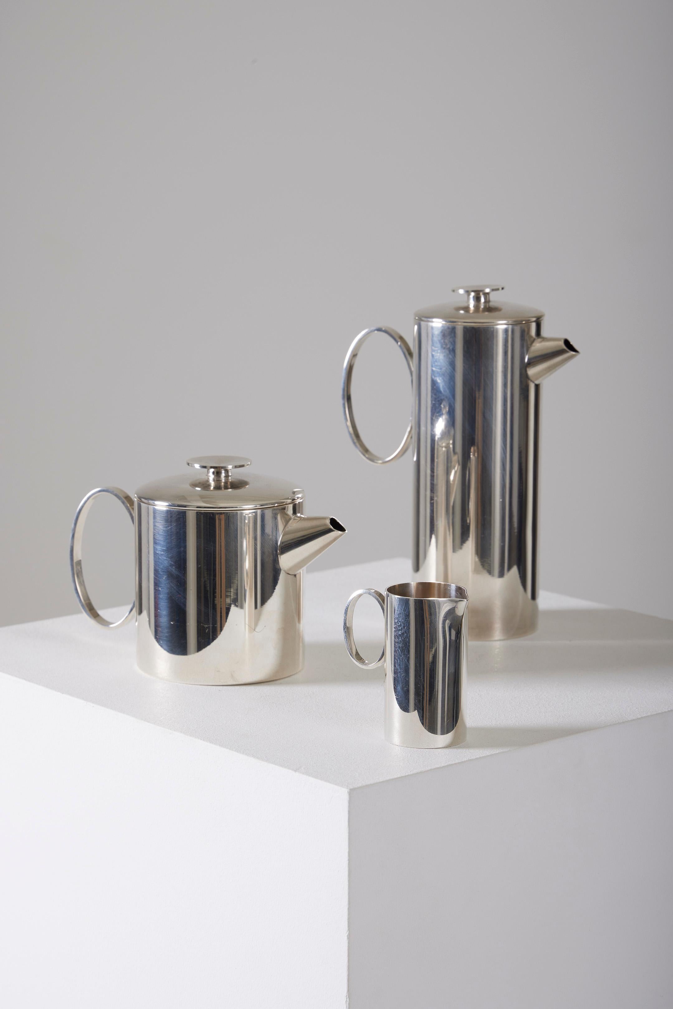 Tea set by Italian designer Lino Sabattini. This silver-plated set includes 2 teapots, one large (L.16 cm / W.16 cm / H.22.5 cm) and one small (L.18 cm / W.18 cm / H.13.5 cm), both with spherical handle lids. The set also includes a small milk jug.