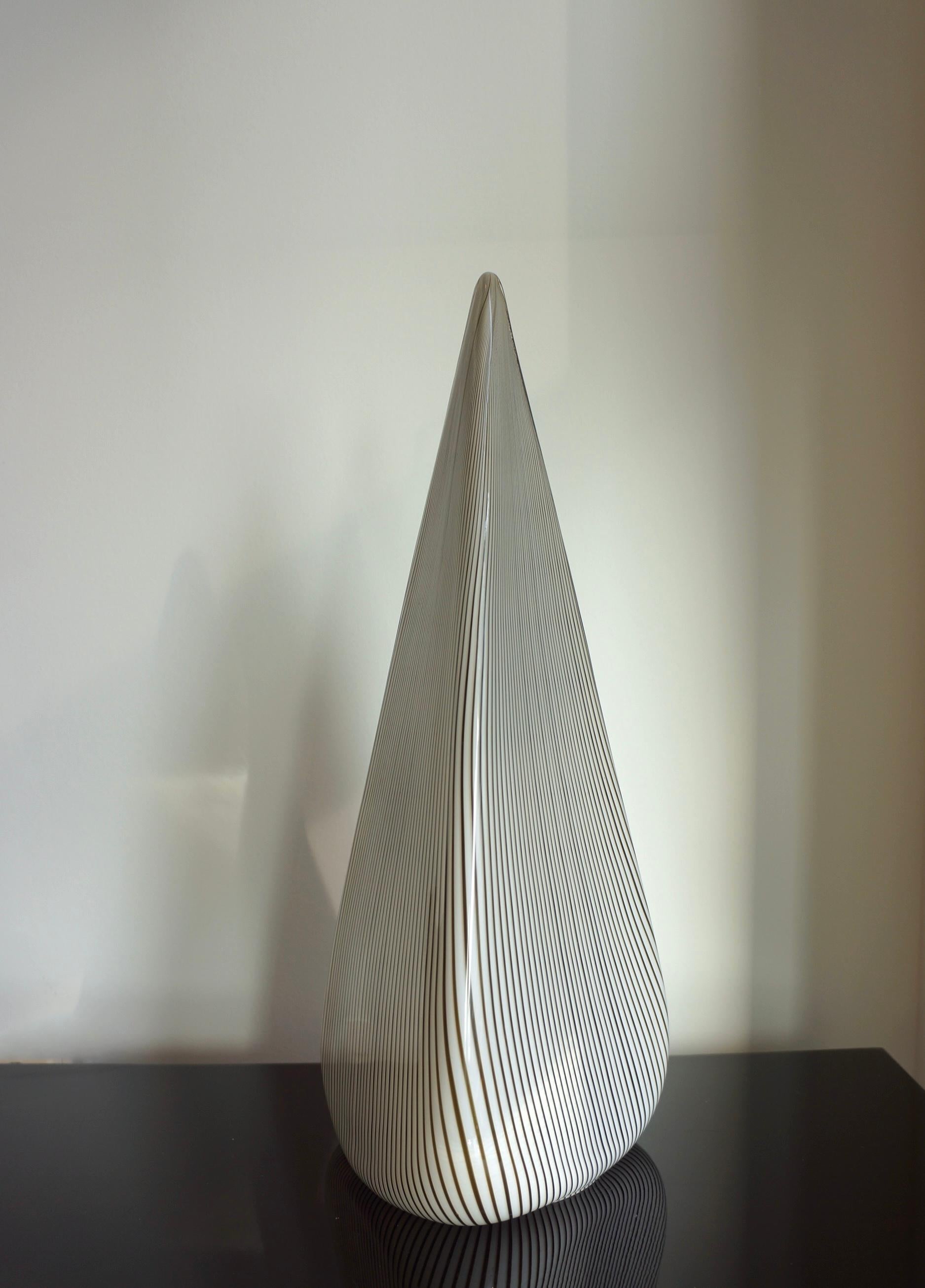 Unique Murano art glass table lamp by Lino Tagliapietra made in the 1970s. This distinctive Murano lamp is shaped in a stretched triangular figure with thin lines of brown and black glass running vertically throughout the piece. The 'Filigrana'