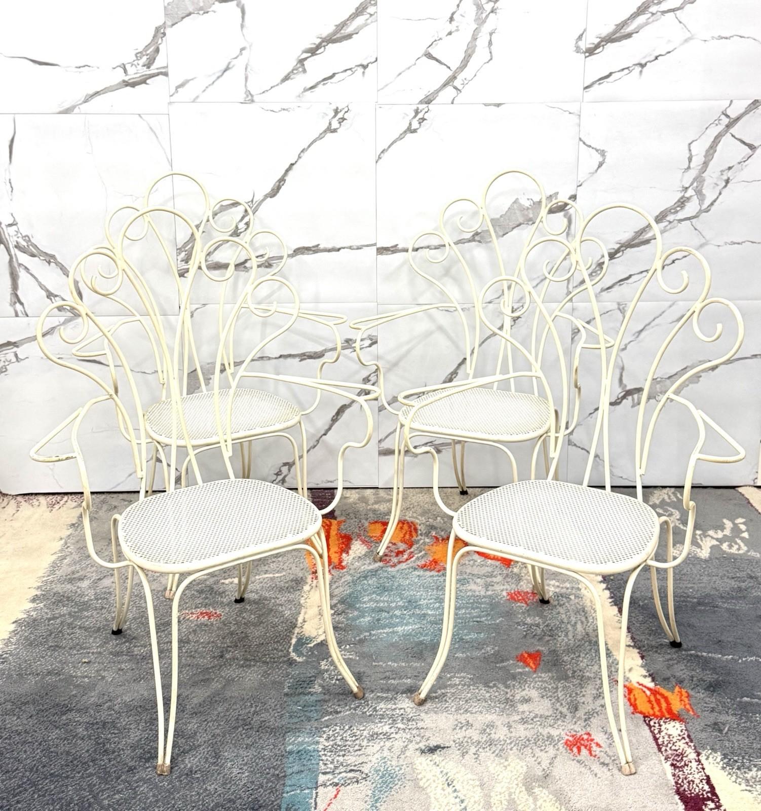 Elégant ensemble de 4 chaises de jardin attribuées à Lio Carminati, en fer forgé émaillé blanc. Un exemple raffiné du design des années 1950, caractérisé par des lignes sinueuses et légères qui rappellent les motifs floraux et naturels, typiques du