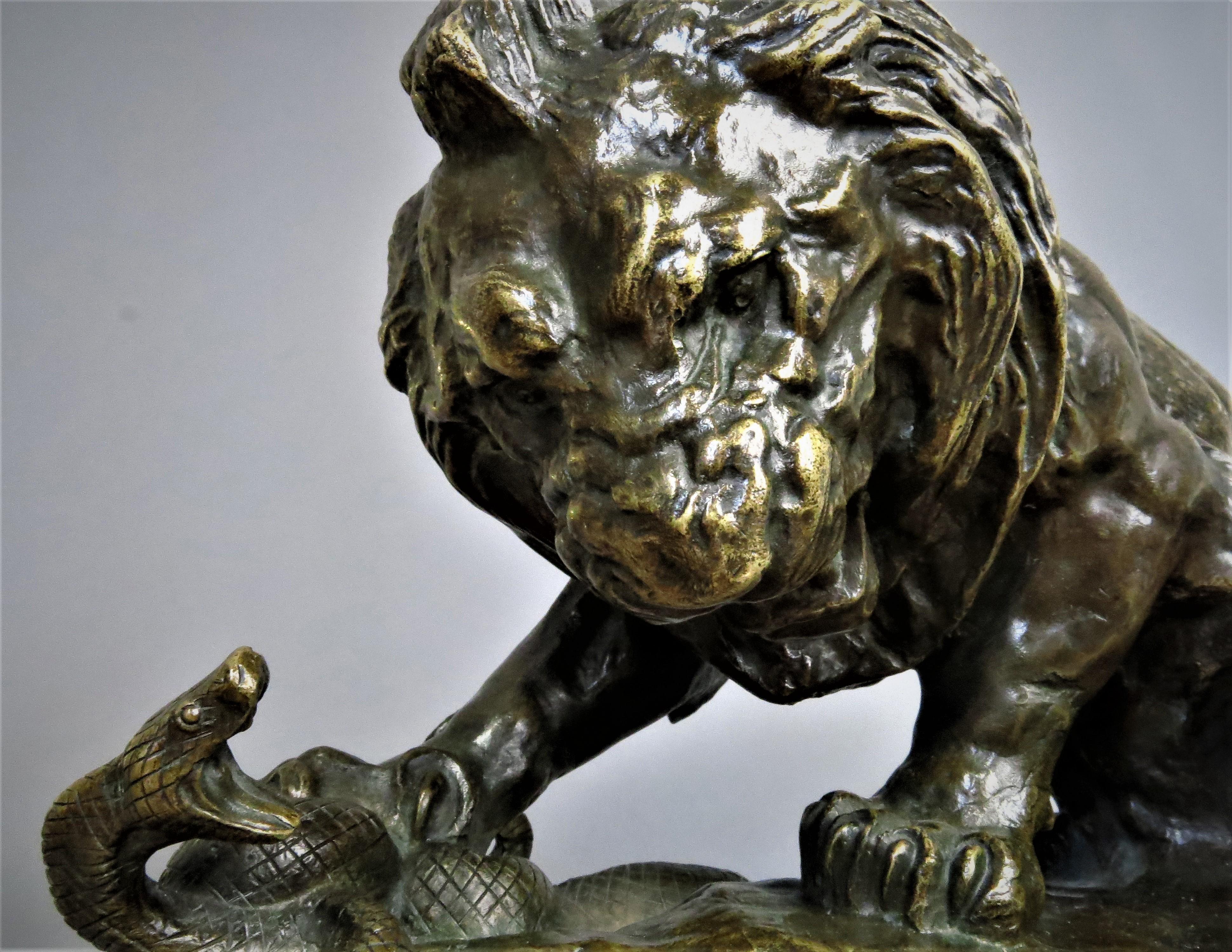 Sculpture en bronze à patine brun doré, représentant un lion combattant un serpent, signée Barye sur la base, à l'arrière de l'animal, près du postérieur droit. La terrasse est décorée d'un profil, le plan de travail est nerveux, très libre, presque