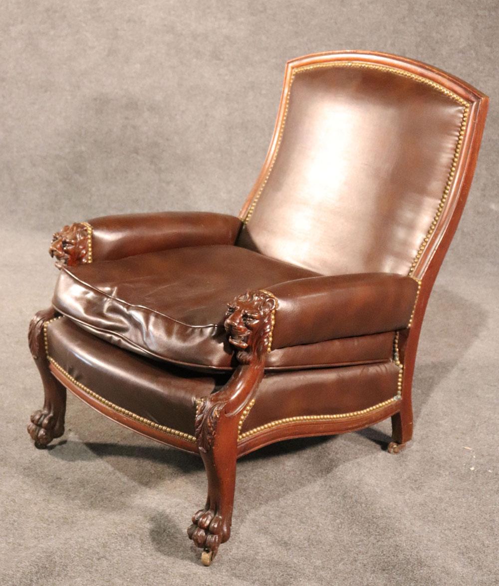 This is a fantastic genuine leather upholstered Paine's furniture company lounge or library chair with carved lion heads on the arms, circa 1870s. The chair is in extremely good condition for its age and has beautiful upholstery and the frame is in