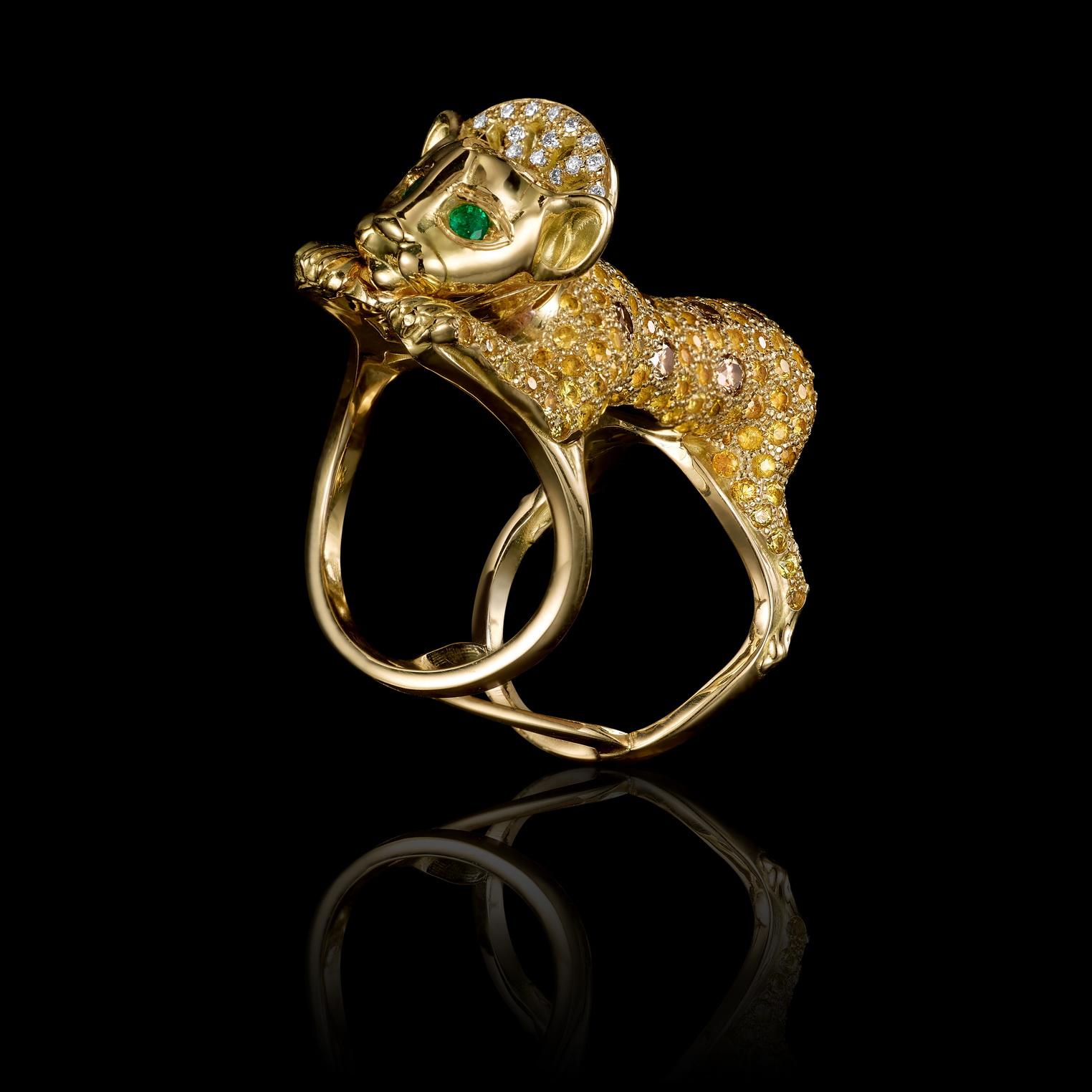 Lion Cub ring in 18K gold, cognac and clear diamonds pave and emerald eyes. 

This ring depicts a young cub in a state of play – holding on to the wearer’s finger and at the same time reaching toward something that caught its interest. Its soft