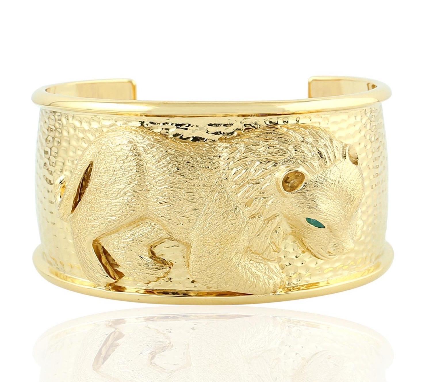Cast in yellow gold finish and sterling silver.  This beautiful lion motif cuff is hand set with textured pattern & .18 carats emerald. 

FOLLOW  MEGHNA JEWELS storefront to view the latest collection & exclusive pieces.  Meghna Jewels is proudly