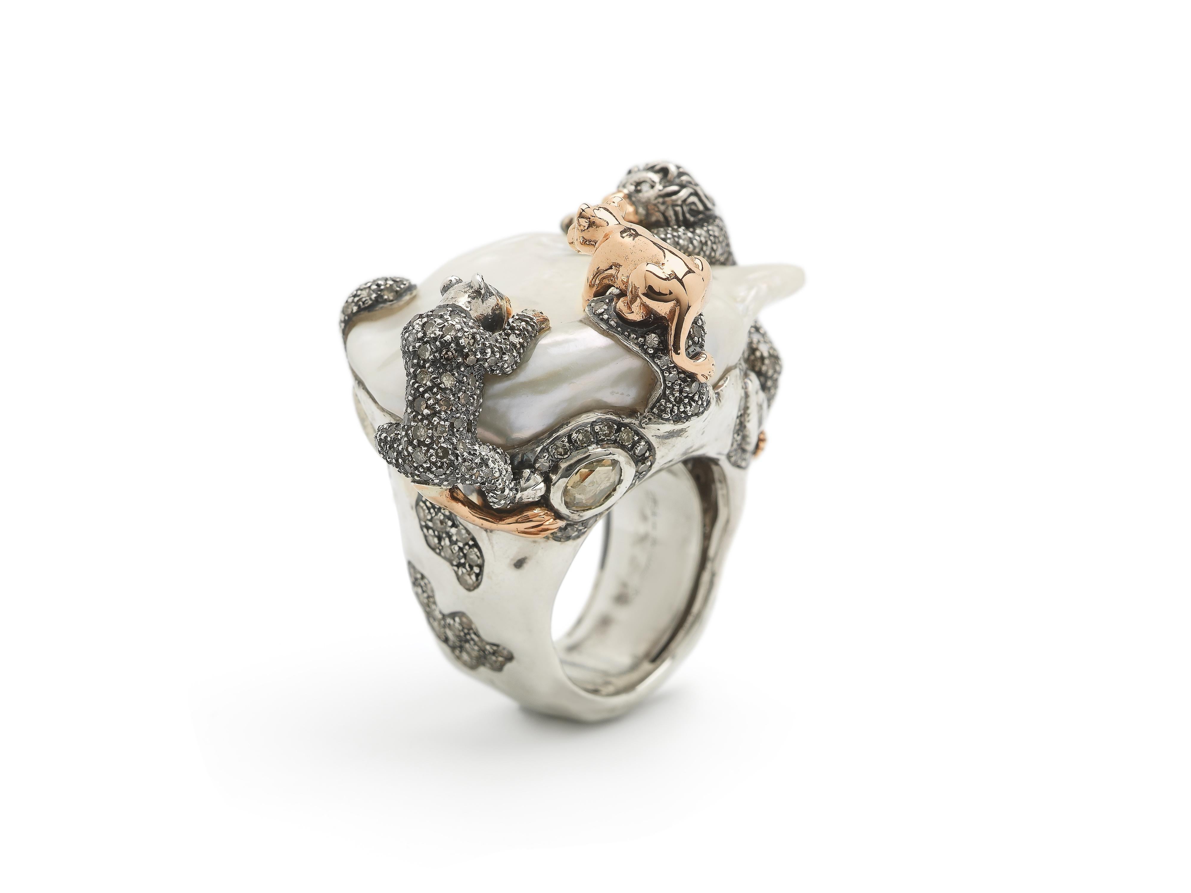 A luminous baroque pearl is home to a family of lions in this striking cocktail ring, part of Bibi van der Velden’s Animal Collection. The sterling silver ring is set with three lions fashioned in 18k rose gold and sterling silver, with the design