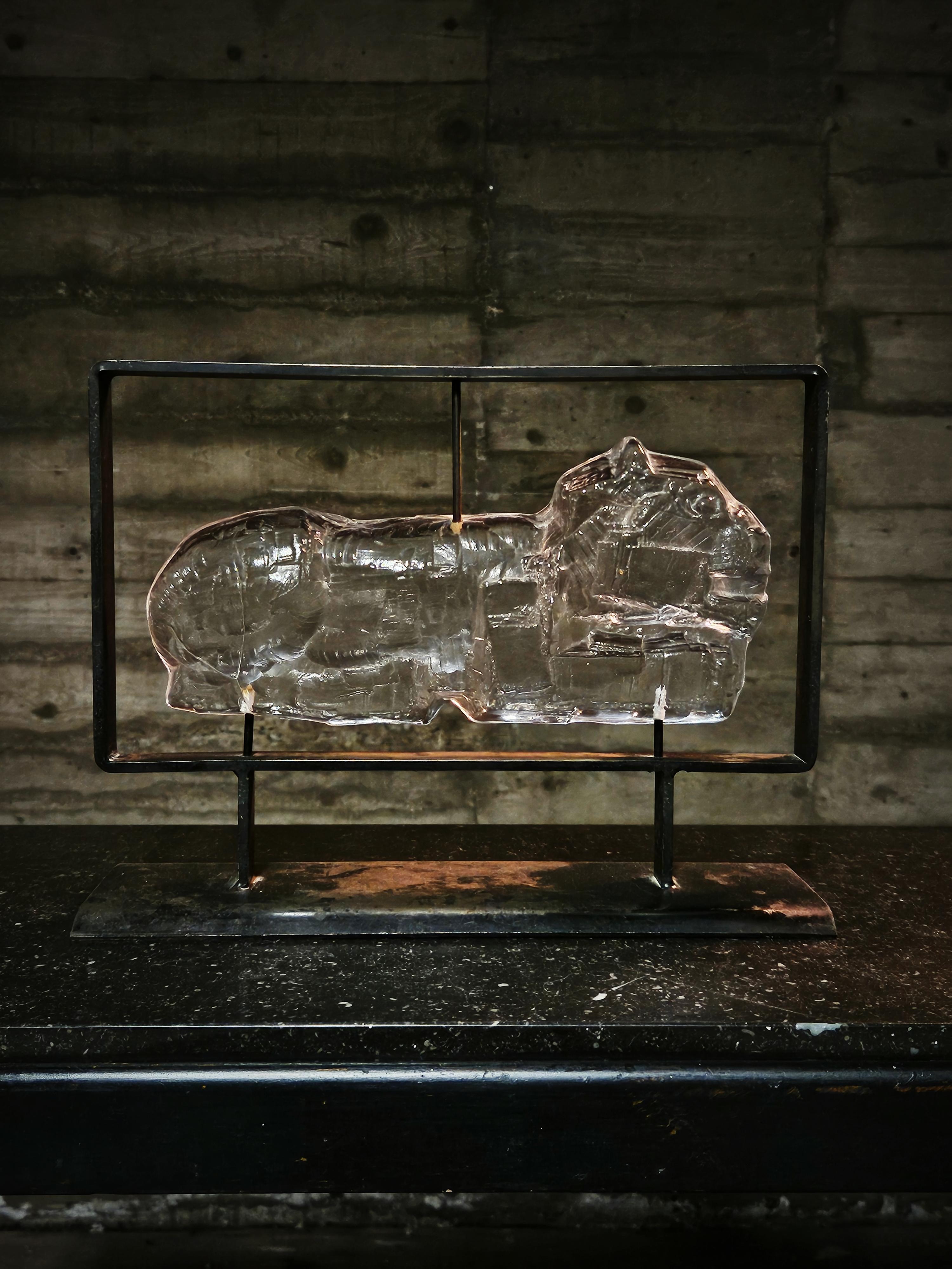 Glass sculpture of a lion mounted on a rustic steel frame. Erik Höglund designed this piece for Boda glasbruk in the middle of the 20th century. 

Partly worn surface on frame. Glass in excellent condition. 
