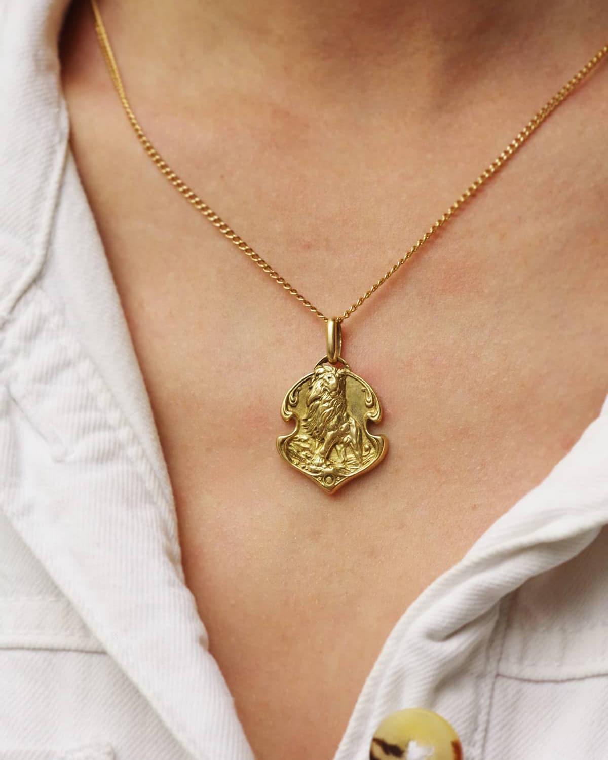 Lion Gustave Soury medal in 18 karat gold. Art Nouveau pendant depicting a lion, surrounded by sinuous and undulating lines, known as “whiplash”, emblematic of the Art Nouveau movement. Gustave Soury (1884-1966) is an illustrator passionate about