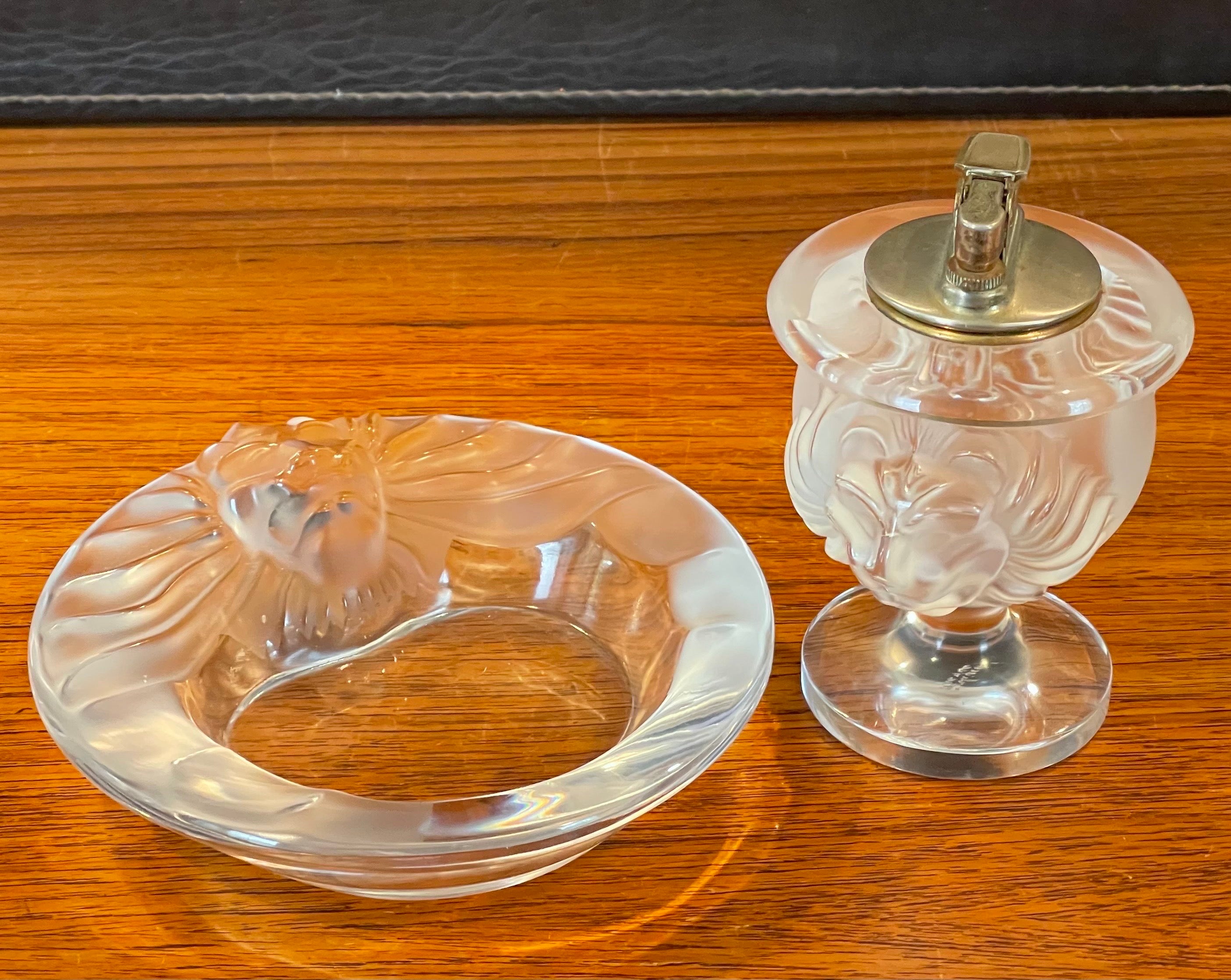Gorgeous lion head frosted crystal ashtray and lighter set by Lalique of France, circa 1990s. This stunning set features a raised lion head with contrast in clear and frosted texture. The ashtray measures 5.75