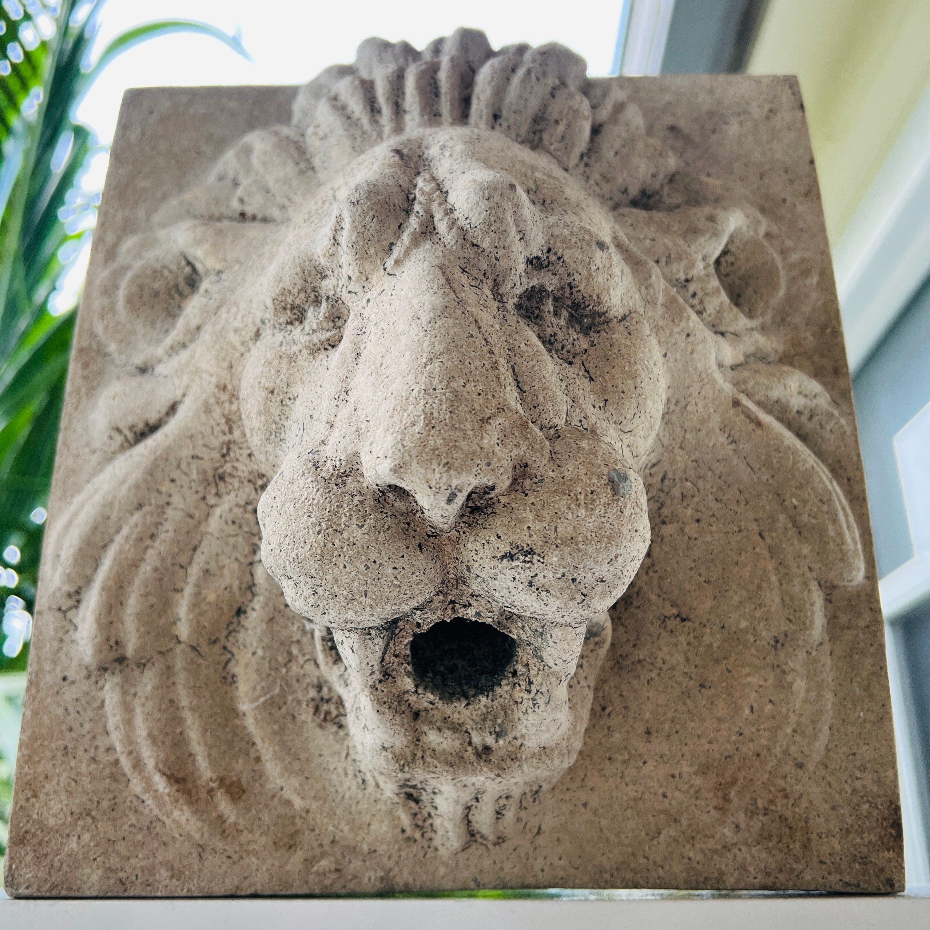 Lion head wall fountain made of cast stone in the style of Beaux Arts movement, incorporating elements of Renaissance, Baroque, and French Neoclassicism. Can we hung on a wall or used as an architectural element. Reverse side is fitted with steal