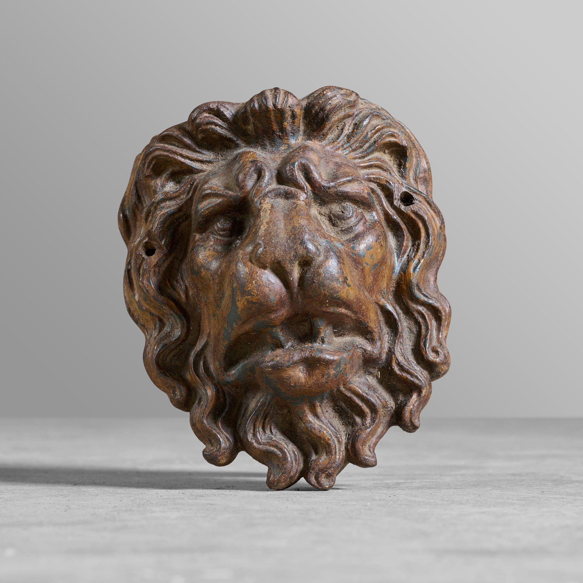 Pair of decorative cast iron lion heads from a Paris building facade. Original patina.