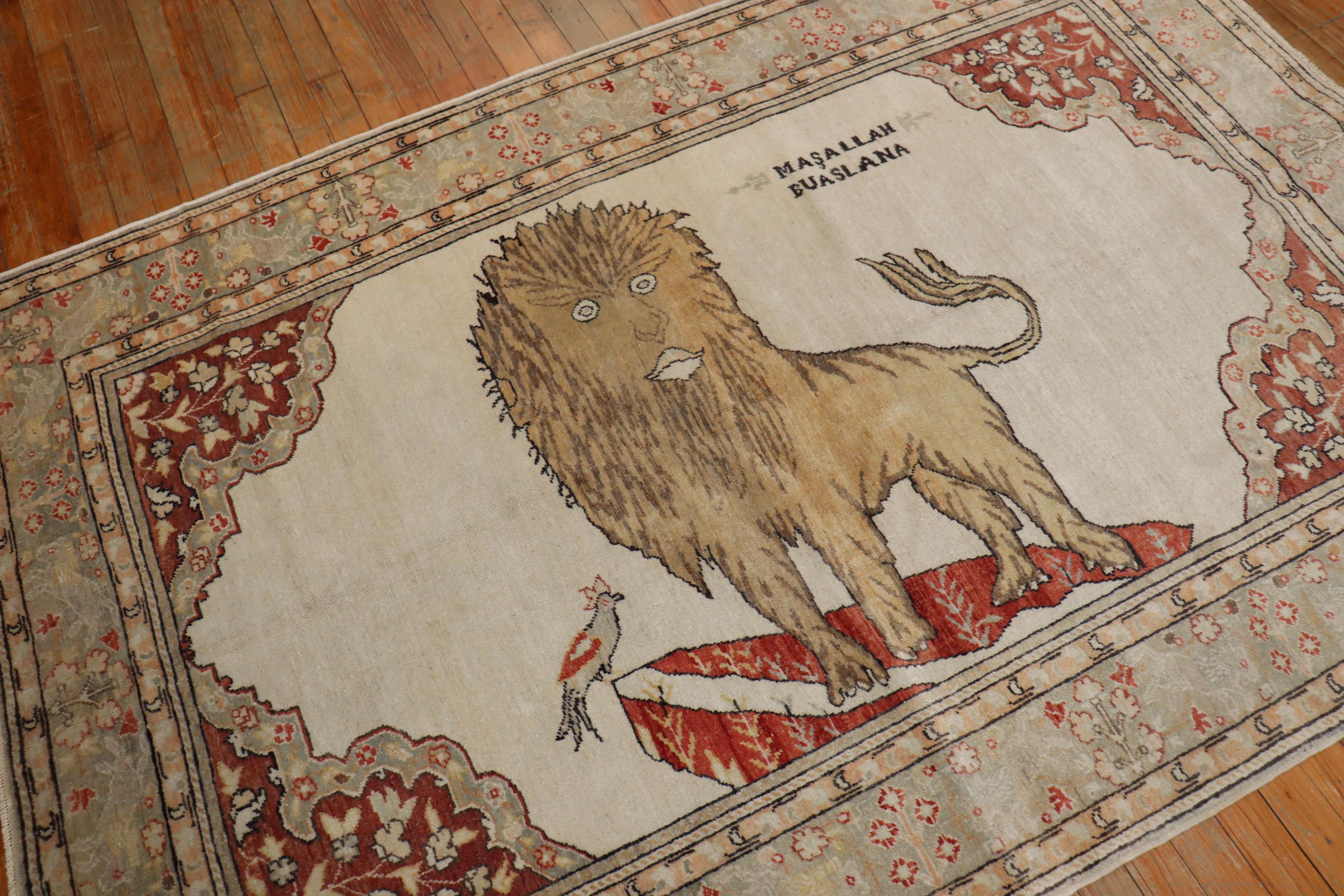 mid 20th century one of a kind Turkish Rug depicting a large lion and small bird on a white field and silver floral border.. The wording 