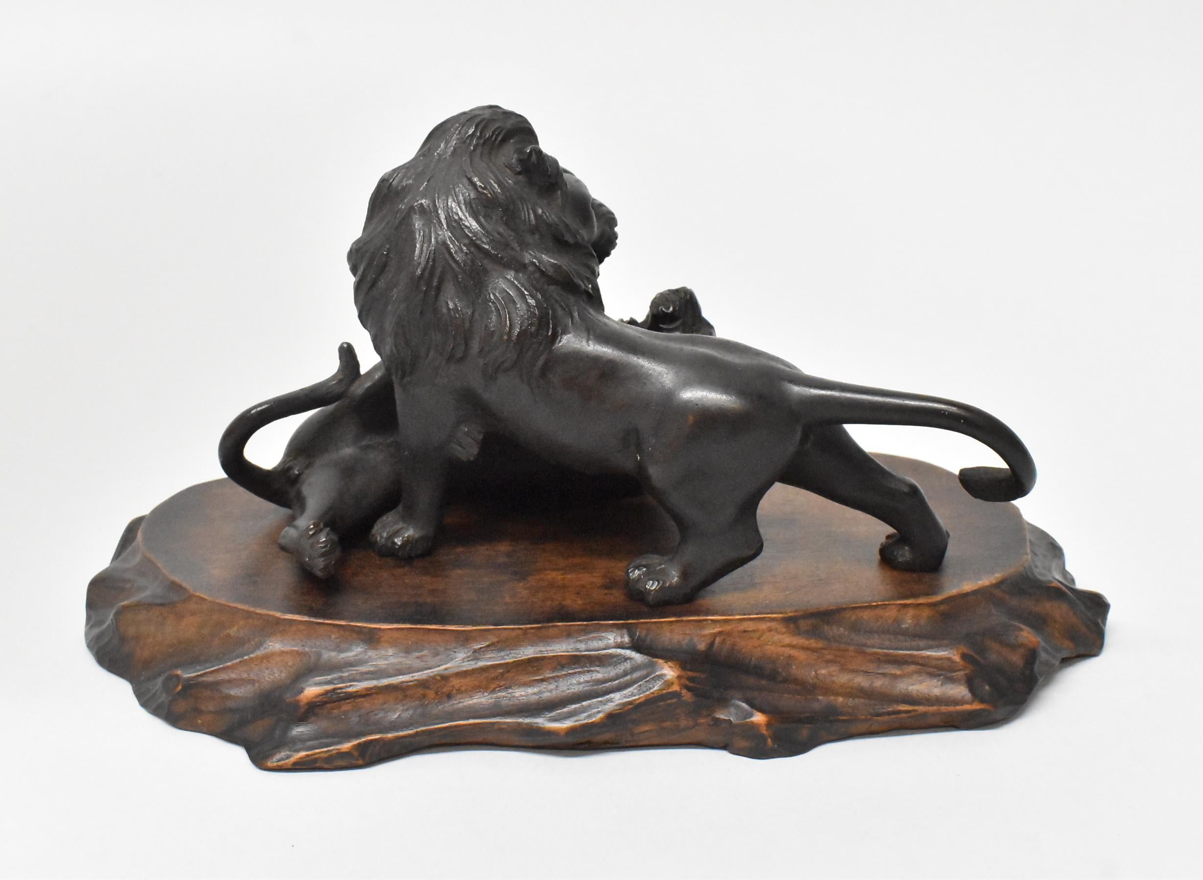 Asiatique Statue de combat lion et tigre en bronze sur plate-forme en bois sculpté marquée d'Asie en vente