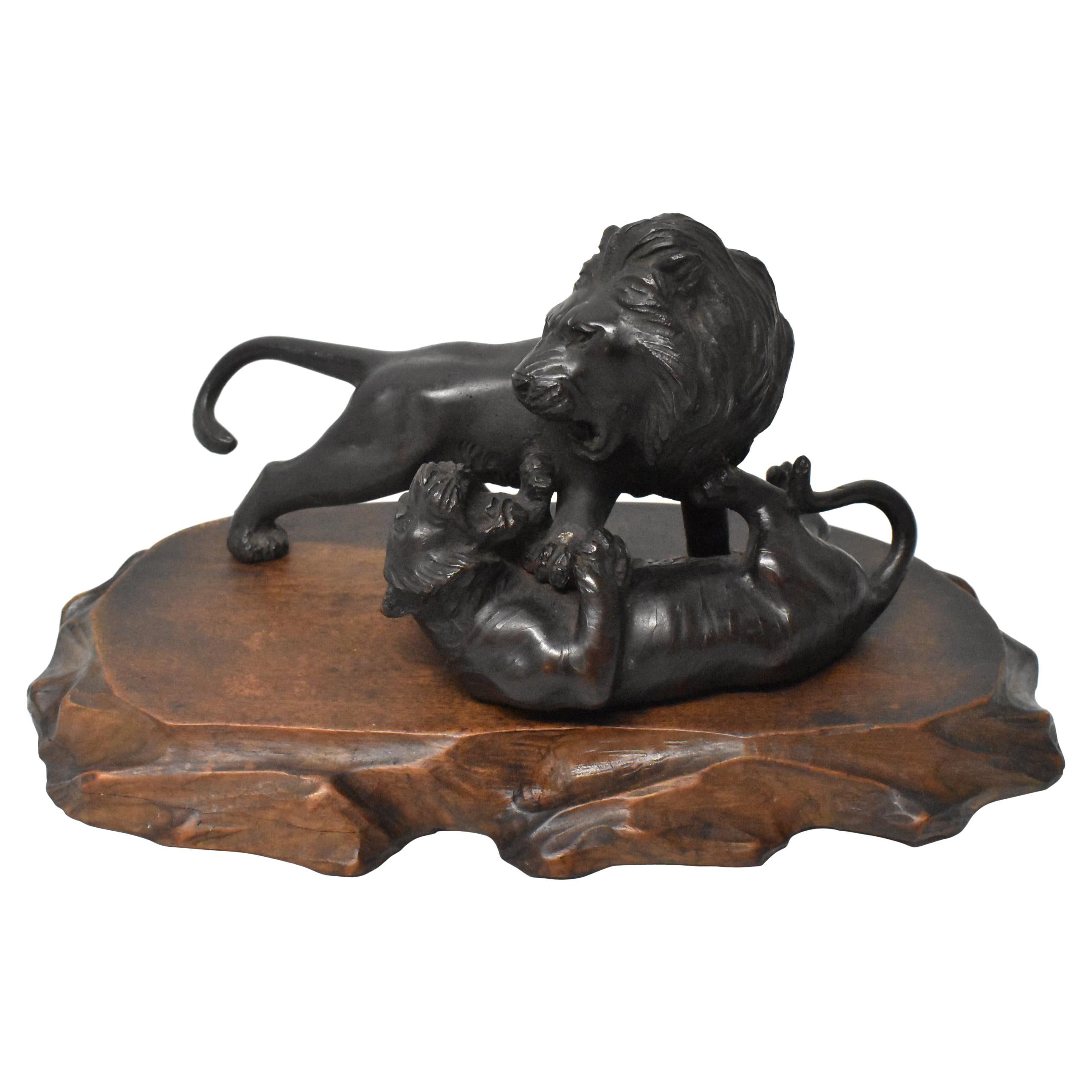 Statue de combat lion et tigre en bronze sur plate-forme en bois sculpté marquée d'Asie en vente