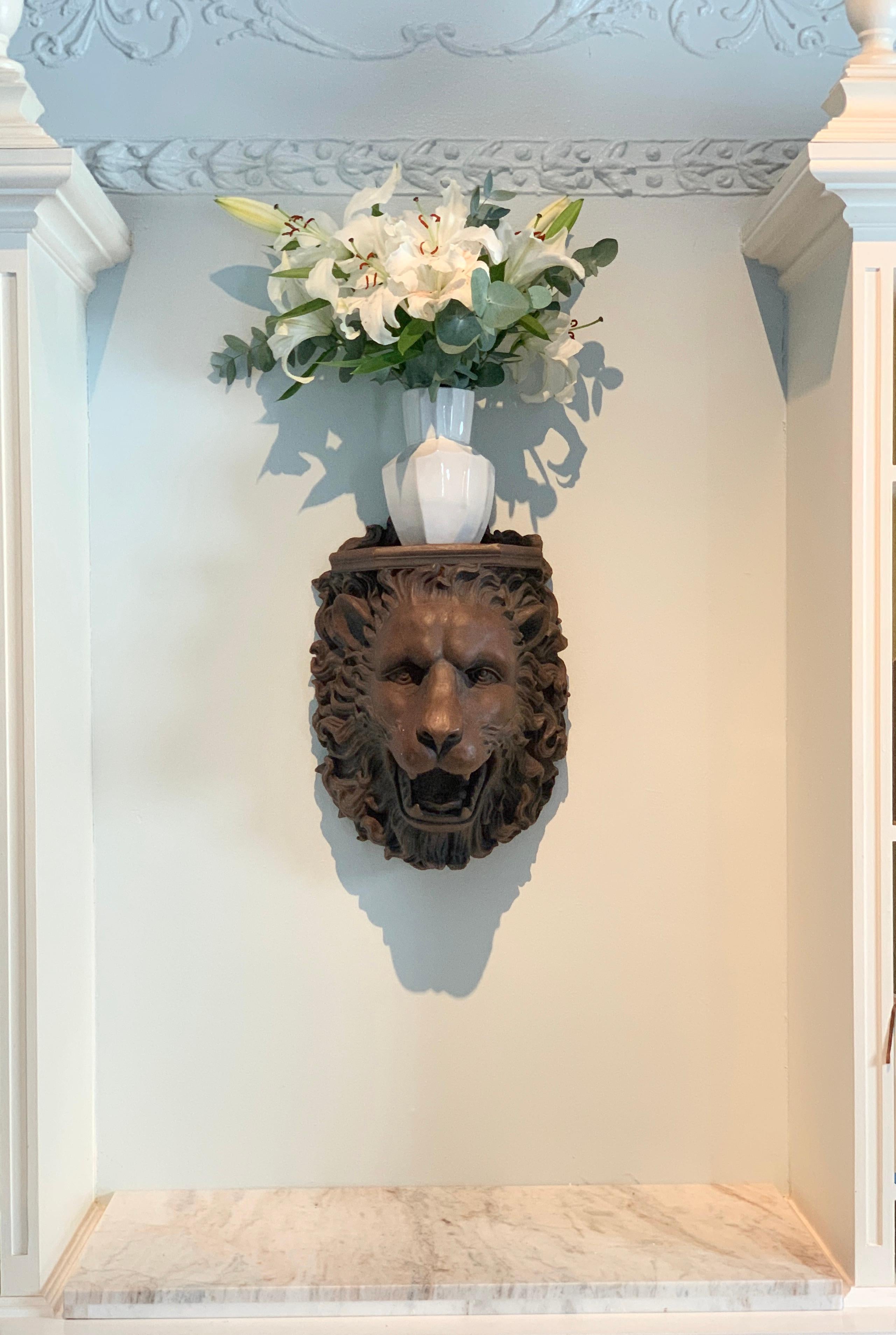 A wall shelf with a great lion face. The shelf is made of a resin and mounts with two holes in the rear. We have photographed the piece with a vase of flowers on the top as example, but the piece presents wonderful without anything atop.