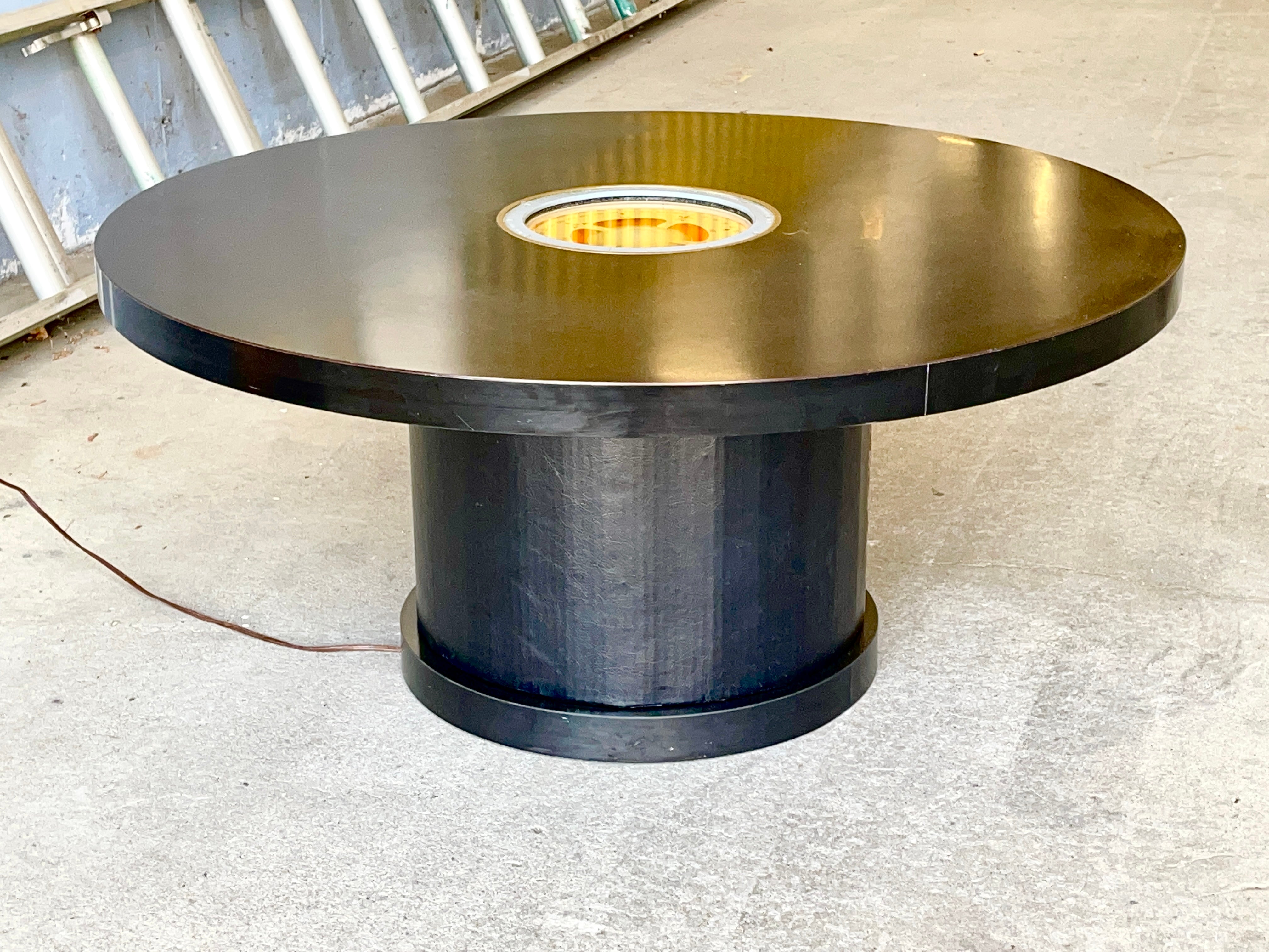 Round black laminate coffee table on recessed columnar pedestal base. Top inset with U.S. Navy gimbaled compass manufactured by the Lionel Corporation, New York. As part of the US War Production effort Lionel ceased making model trains and retooled