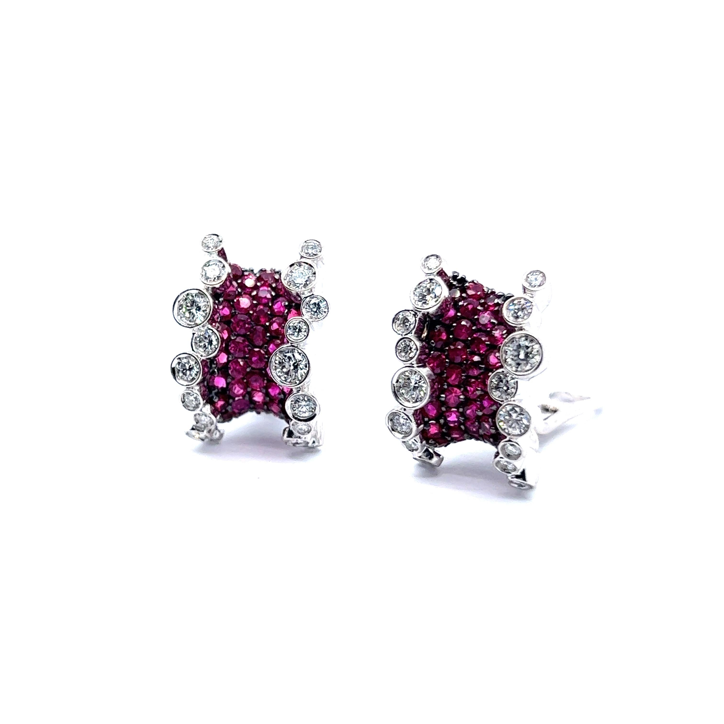 An exquisite pair of earrings with rubies and diamonds in 18 Karat white gold. These beauties are a true testament to luxury and artistry, resembling two exotic fruits or candies captured in the form of jewelry. 

Each earring boasts a luscious