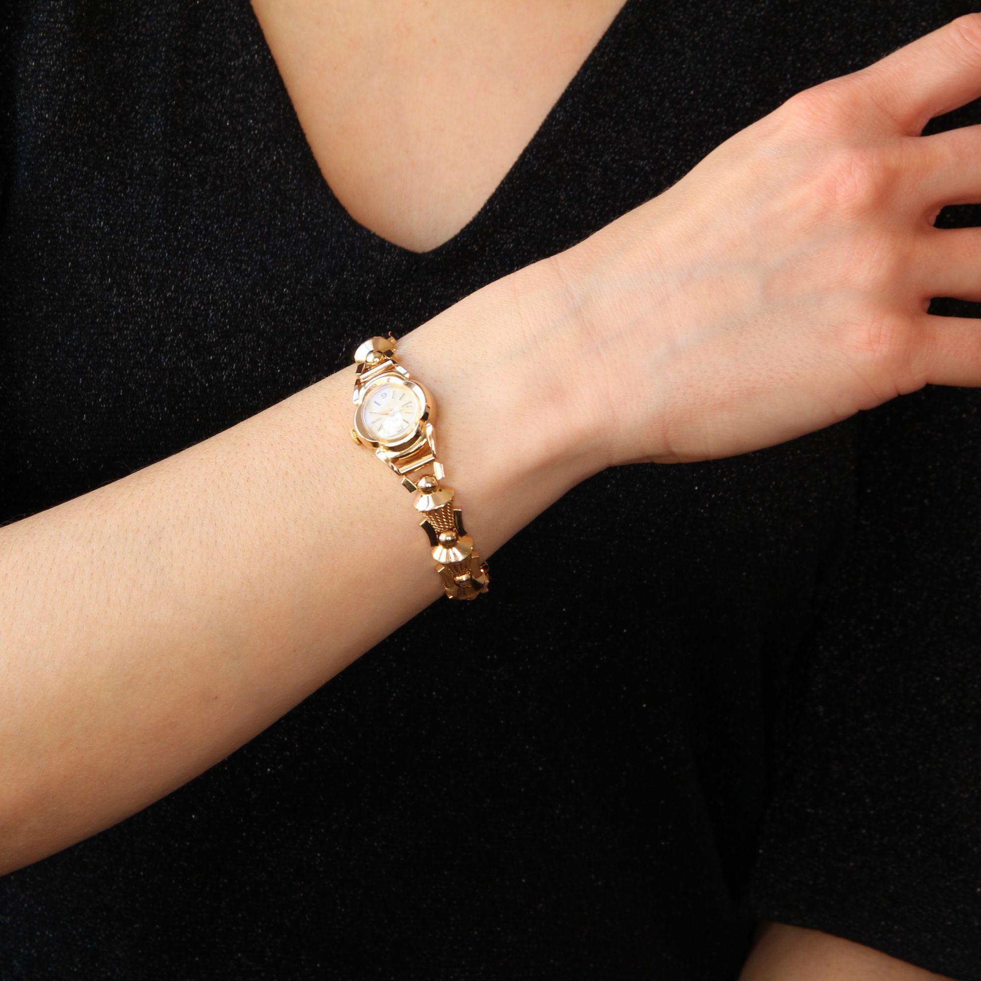 Montre de femme en or jaune 18 carats, poinçon tête d'aigle.
Montre rétro originale pour dame, son boîtier en or est en forme de trèfle à quatre feuilles. Le fond est blanc crème, les aiguilles et les chiffres, dorés.
Le dos du boîtier porte le