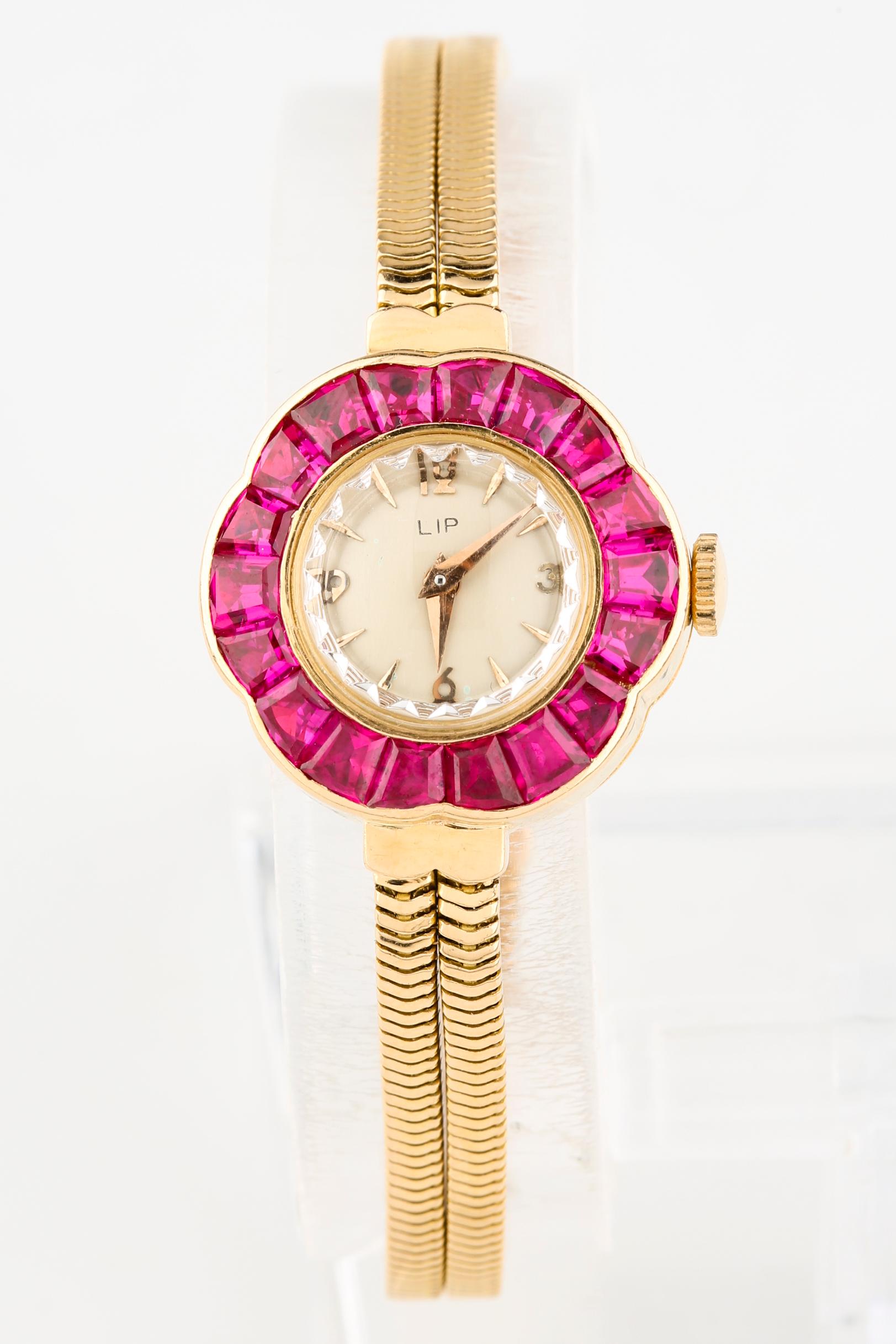 18k Yellow Gold Flower-Shaped Case
23 mm in Diameter (24.5 mm w/ Crown)
Bezel Features 18 Custom-Shaped Rubies in Ballerina Baguette Formation
Round Dial w/ Gold Tic Marks and Hands (M + H)
Features Crystal Faceted Along the Border
14 mm in