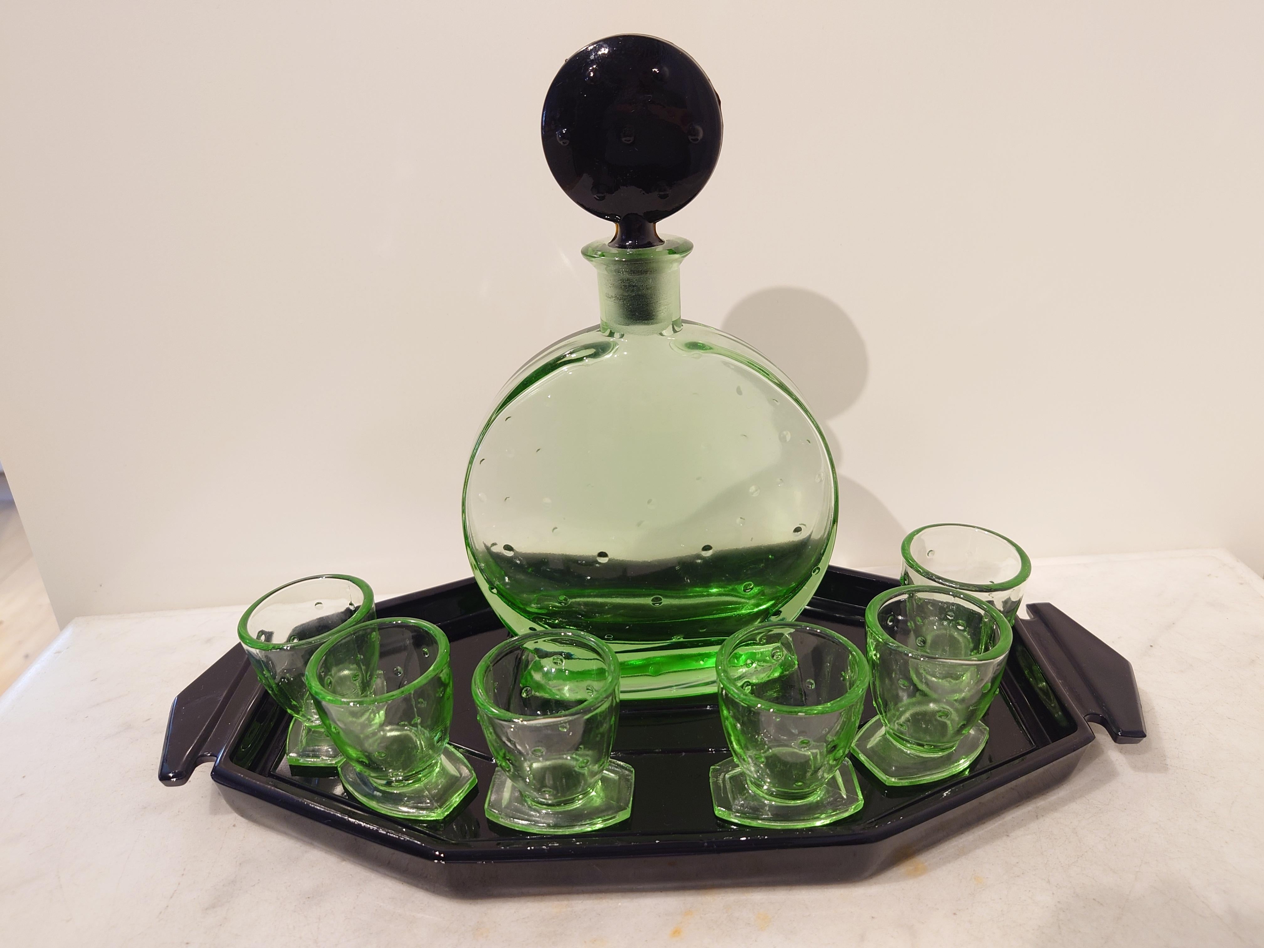 Köstliches dekoratives Likörservice Art Deco 30er Jahre
Steht auf einem köstlichen schwarzen Glastablett mit Karaffe und 6 Likörgläsern in einer coolen Form und stilvollen schwarzen Elementen. Das Glas ist aus Uranglas und glänzt fantastisch mit