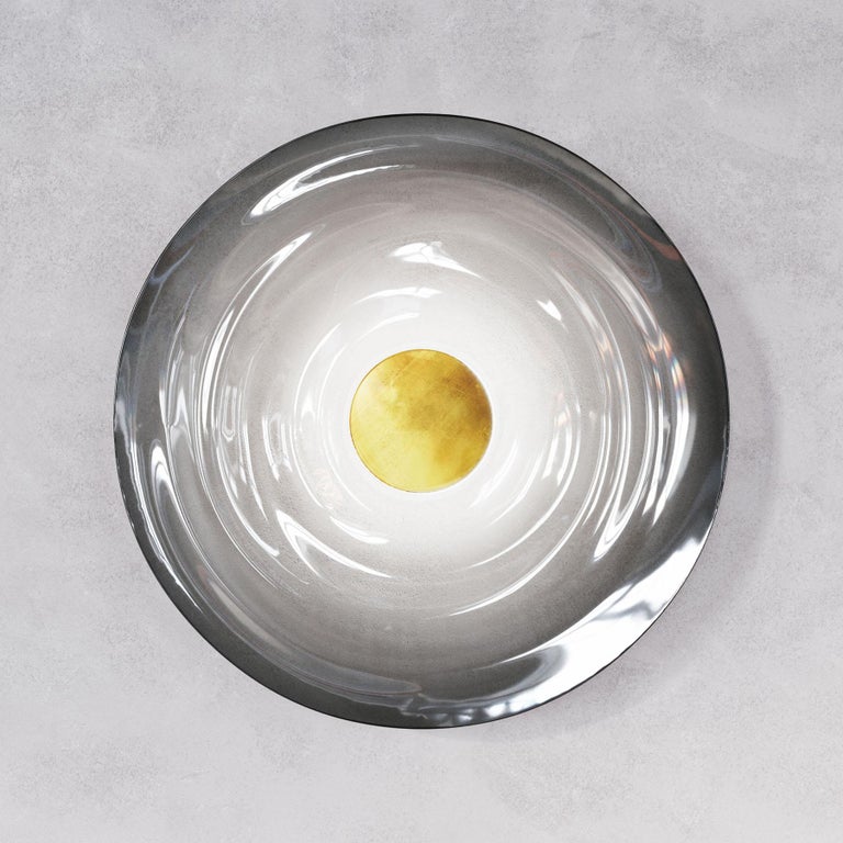 Liquid Smoke wall light is designed by international illumination artist Eva Menz. Inspired by the circular ripples and reflections created on water, the dark gradient glass is transformed into a beautiful sculptural sconce.

Each piece is handmade