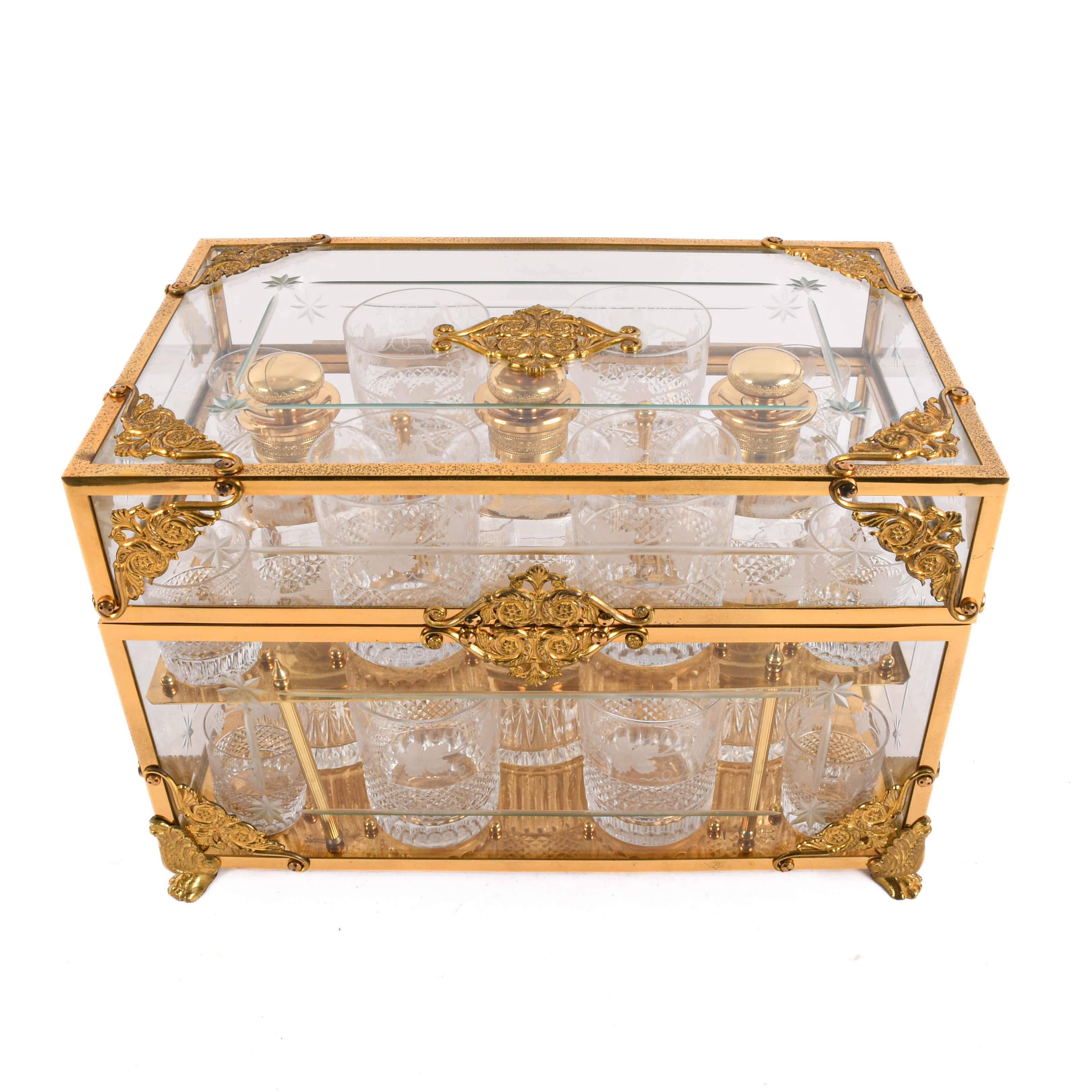 Este exquisito mueble para licores es un golpe maestro de elegancia y utilidad, diseñado para impresionar y servir con estilo. Enmarcada en un brillante marco de latón con paneles de cristal biselado en todos los lados, esta pieza muestra su