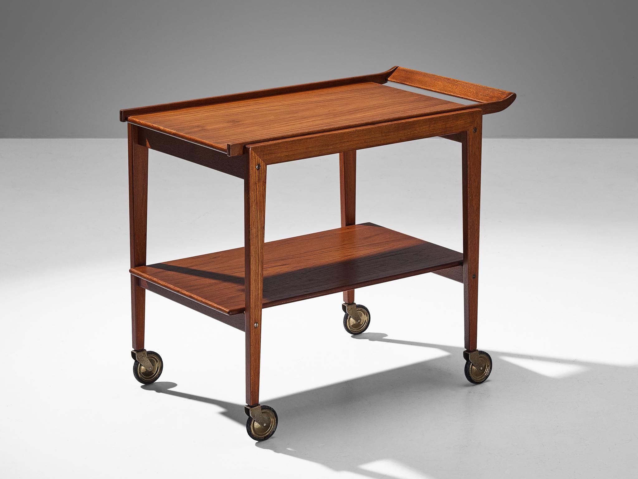 Trolley or bar cart, teak, metal, Europe, 1960s.

This solid bar cart has been executed in wood. The piece has a solid wooden frame and two shelves. The piece has four wheels so it can be used as a trolley. The natural materials form a modest