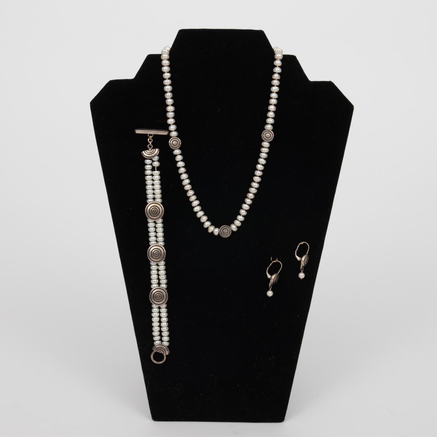 Lisa Jenks matched set, sterling silver and pearls. Necklace 16.00 Inches long with sterling medallions. Bracelet 7.50 Inches long, double strand pearls with sterling medallions. Earrings 1.125 Inches long with pearl and medallions, pierced. Please