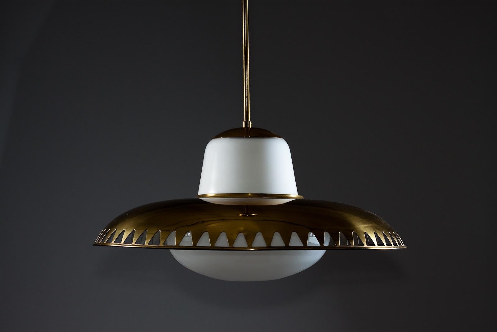 This stunning Lisa Johansson-Pape pendant is a perfect addition to any vintage design lighting collection. The decorative brass pendant features a beautiful glass design by Gunilla Jung, and the brass lamp shade is designed by Lisa