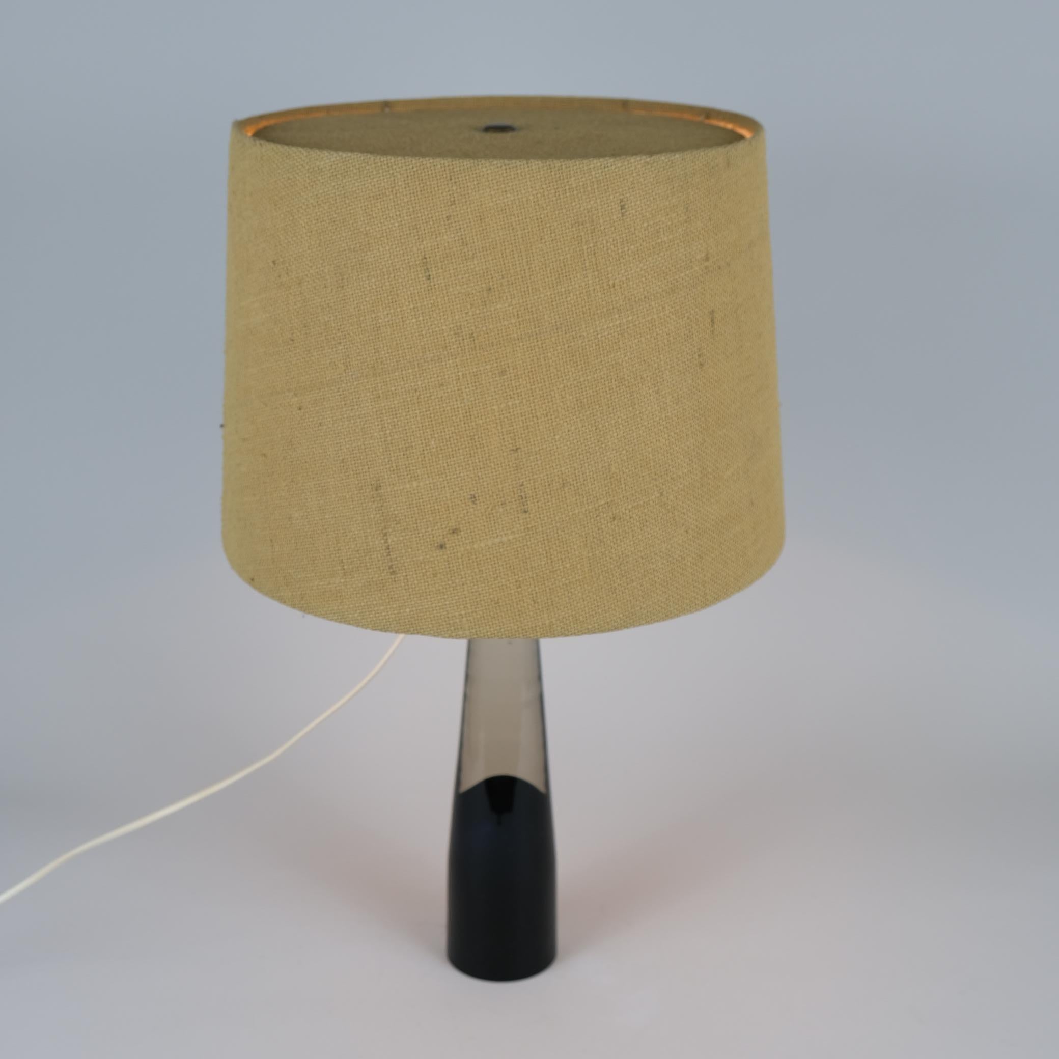 An exceedinlgy beautiful table lamp designed by Lisa Johansson-Pape and manufactured by Orno in Finland in the 1950s. Featuring a dark blue artglass stem, free blown in Iittala, one of the leading art glass manufacturers in Finland. One of the