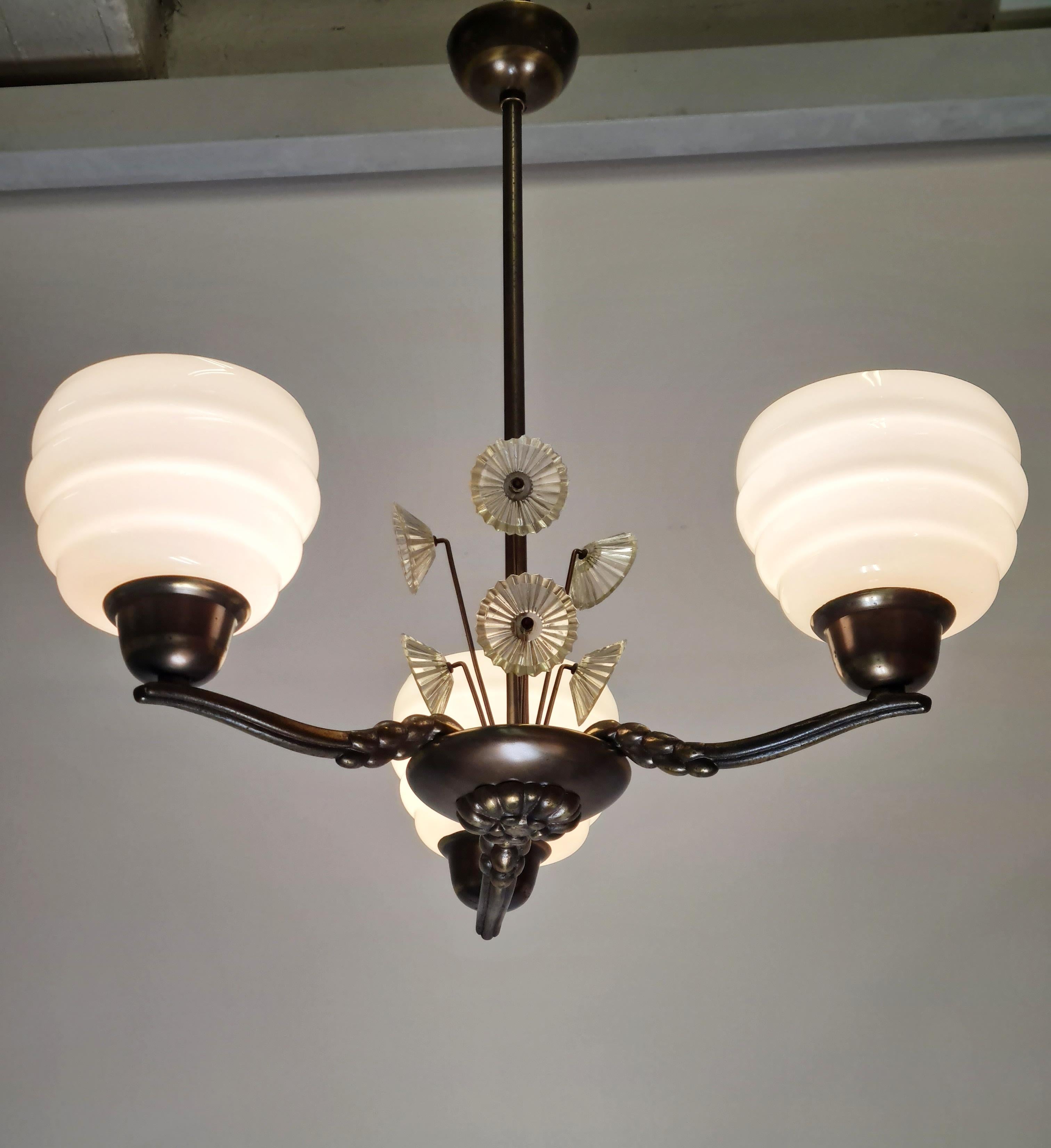 Lisa Johansson-Pape Art Deco ceiling pendant with beehive opaline glass shades and pressed glass flower decorations. The three arm pendant is of patinated dark brass. The lamp shades are mouth blown in beehive shaped wooden moulds at the legendary