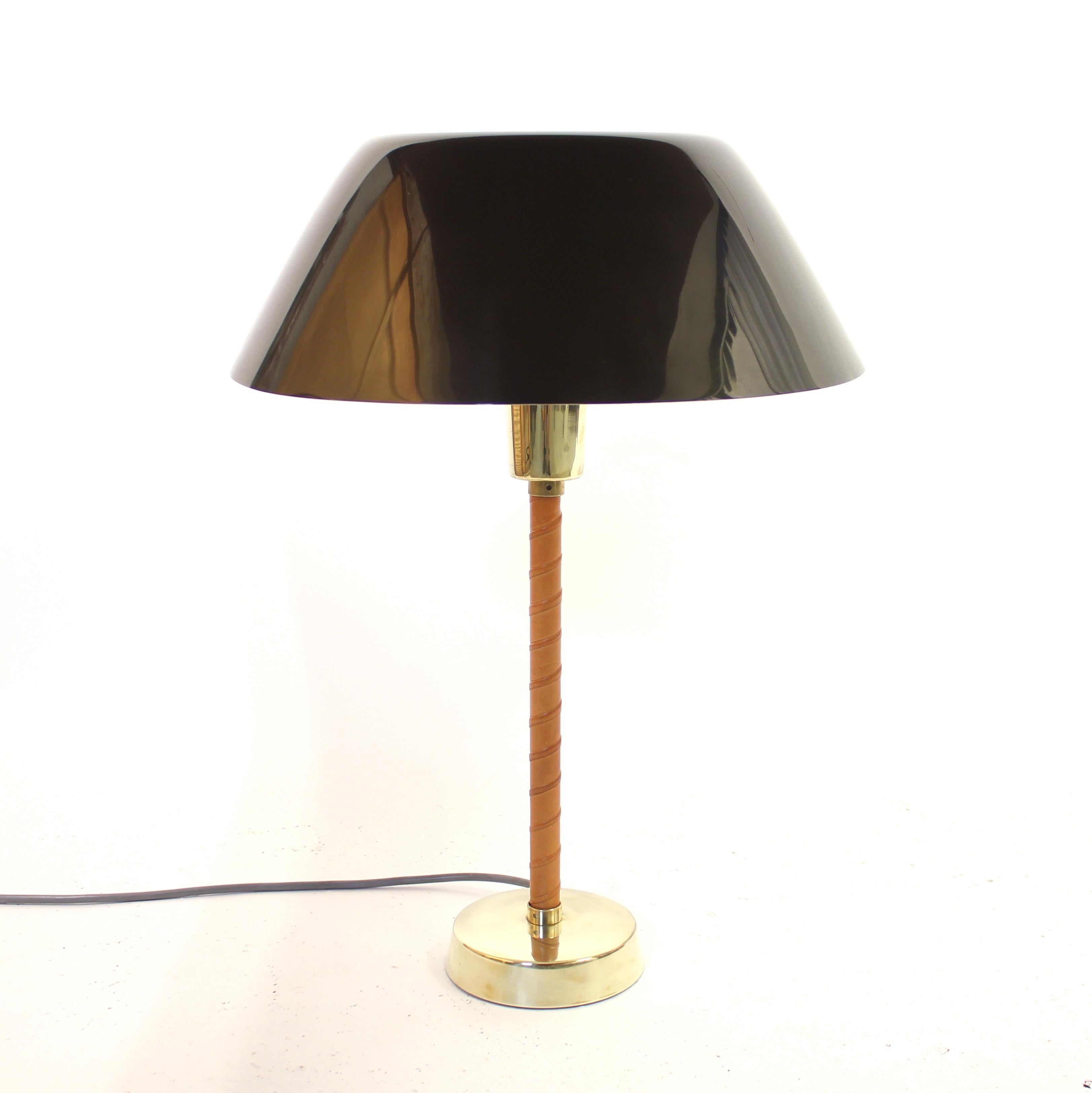 Senator table lamp designed by Finish designer Lisa Johansson-Pape for her long time collaborator Orno in the 1950s. The lamp has a dark green metal shade that are held in place by an acrylic bowl/shade on the inside. Under that is a brass bulb