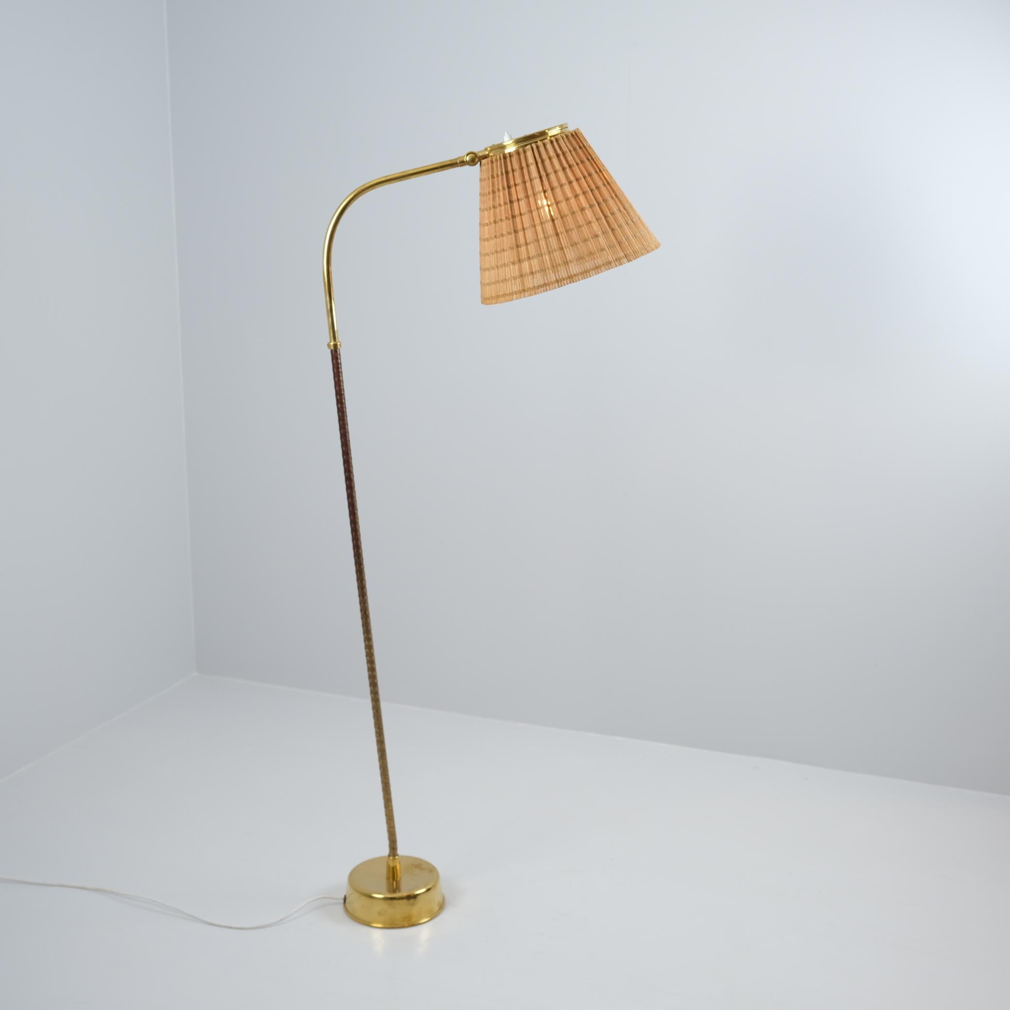A rare Lisa Johansson-Papé floor lamp model. 2063 with adjustable rattan shade and a bent leg in brass and black nylon. Manufactured in Finland by Orno in the 1950s. This lamp is one of the most sought after models designed by Lisa Johansson-Papé.