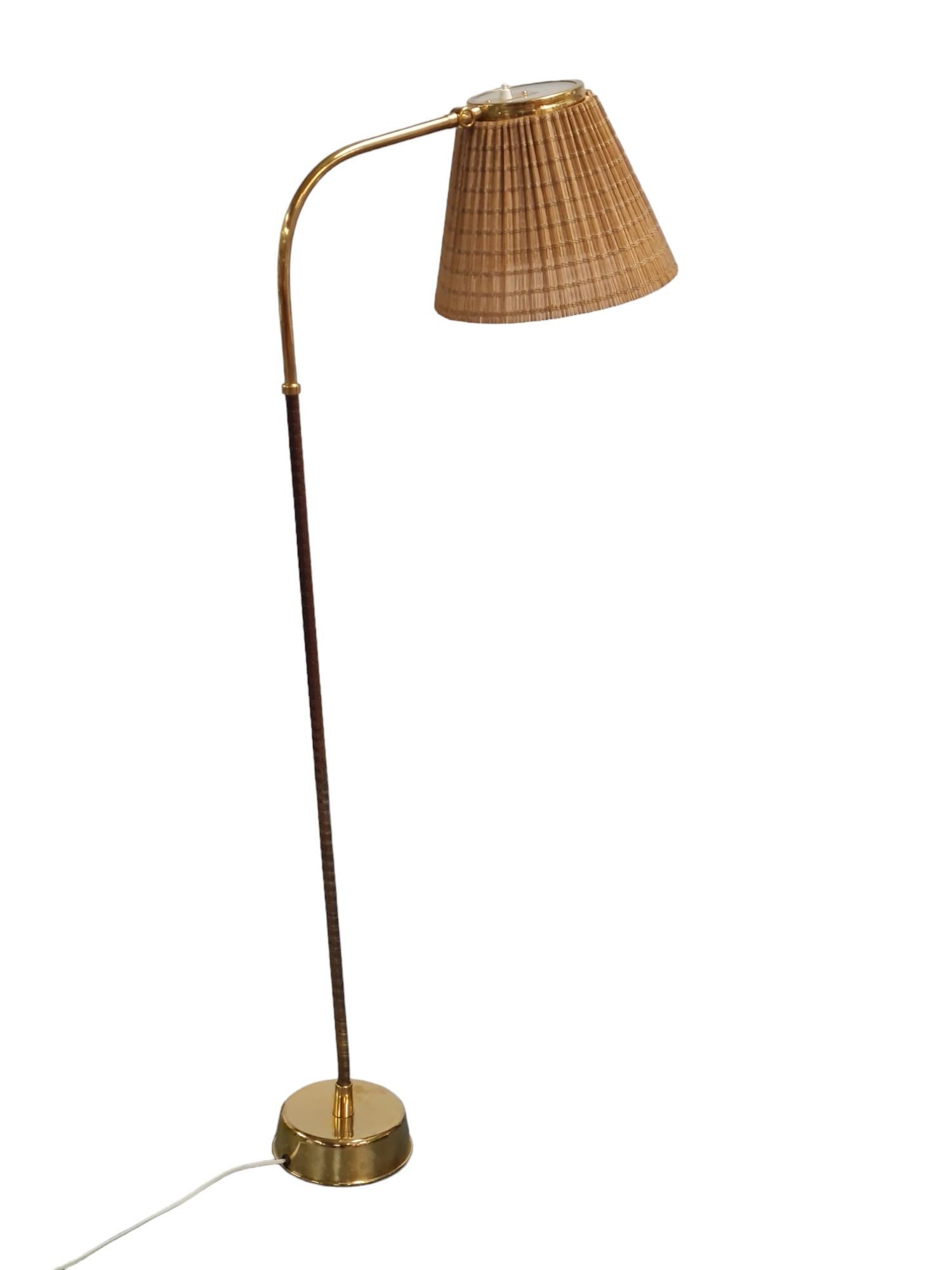 Rare Lisa Johansson-Papé floor lamp model. 2063 with adjustable rattan shade and bent leg in brass and black nylon. Manufactured in Finland by Orno in the 1950s. This lamp is one of the most sought after models designed by Lisa Johansson-Papé. The