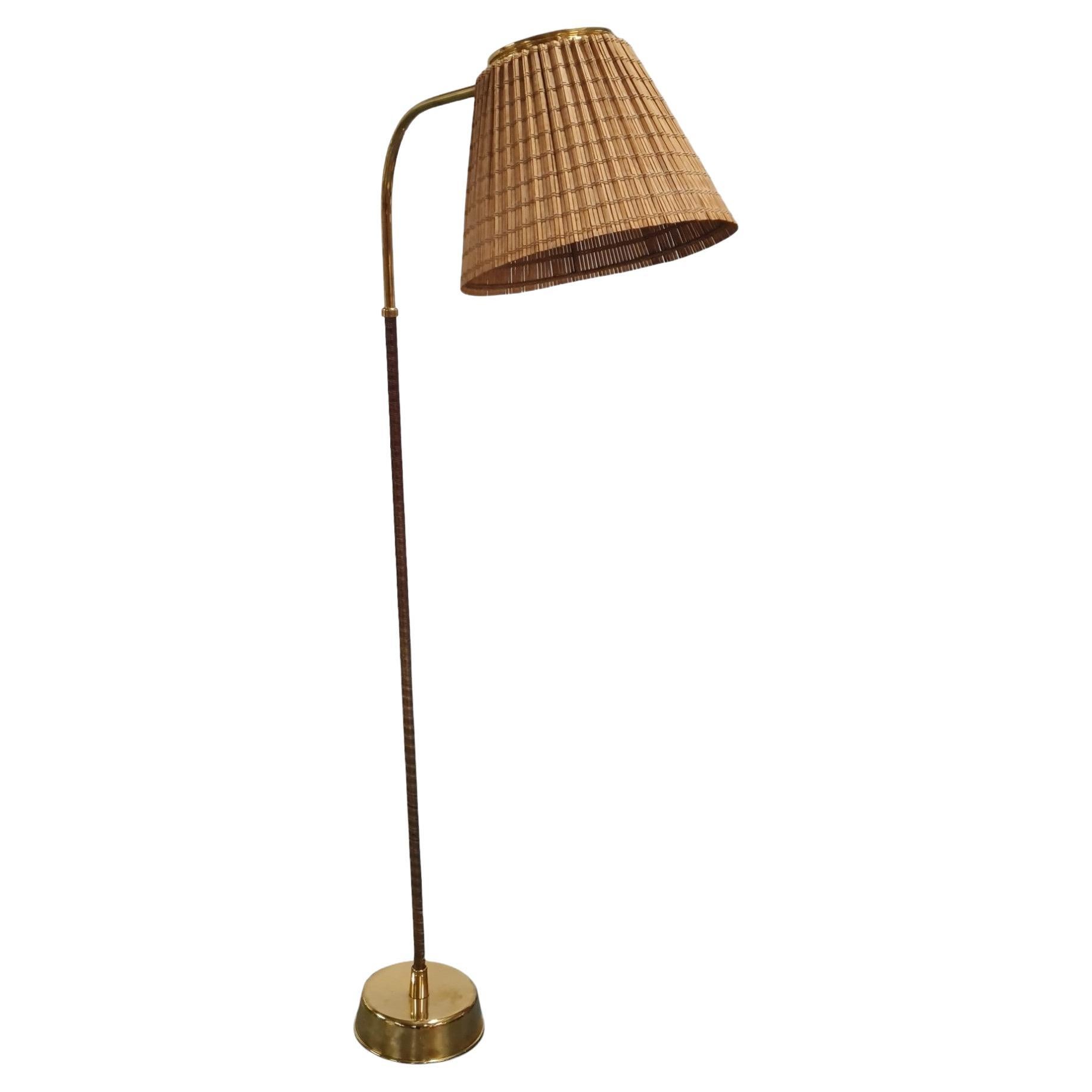 Rare lampadaire Lisa Johansson-Papé modèle. 2063 avec abat-jour réglable en rotin et pied courbé en laiton et nylon noir. Fabriqué en Finlande par Orno dans les années 1950. Cette lampe est l'un des modèles les plus recherchés conçus par Lisa