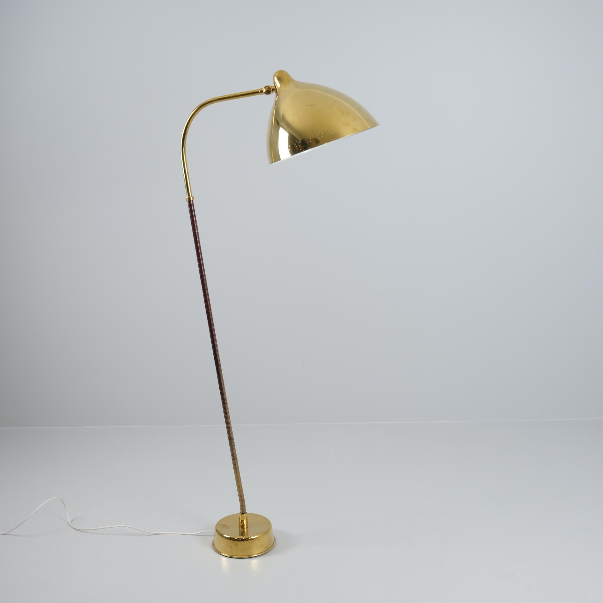 Una bellissima lampada da terra Lisa Johansson modello 30-062 di Orno degli anni '50, con paralume in ottone pieno. La lampada è stata lucidata e tutte le parti sono originali, compreso l'involucro di plastica sullo stelo. La lampada presenta un