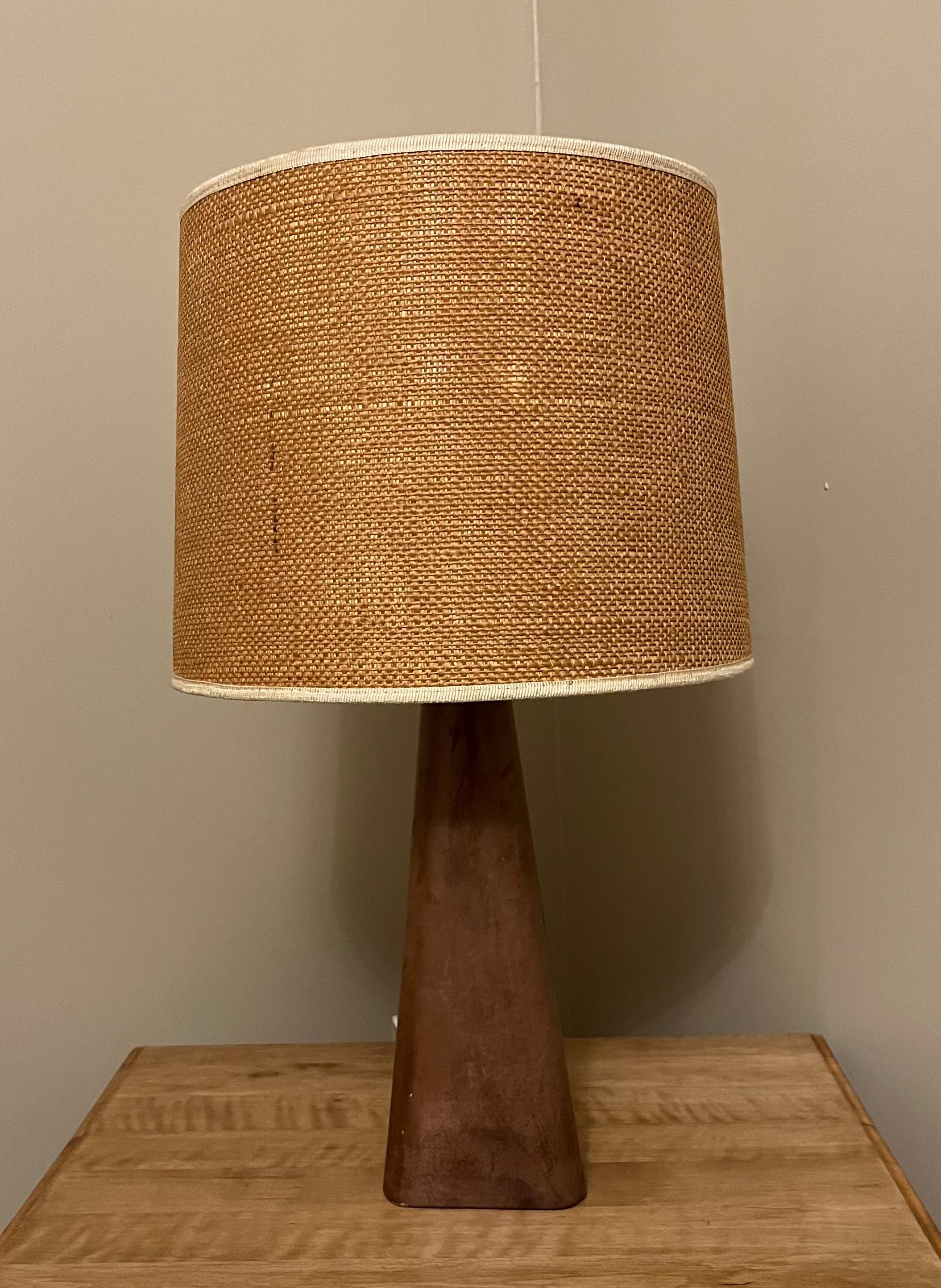 **Lampe de table en cuir avec abat-jour en lamelles de Lisa Johansson-Pape**.

La lampe de table en cuir de Lisa Johansson-Pape, dotée d'un abat-jour en lamelles, est une véritable œuvre d'art qui apporte une atmosphère unique et chaleureuse à
