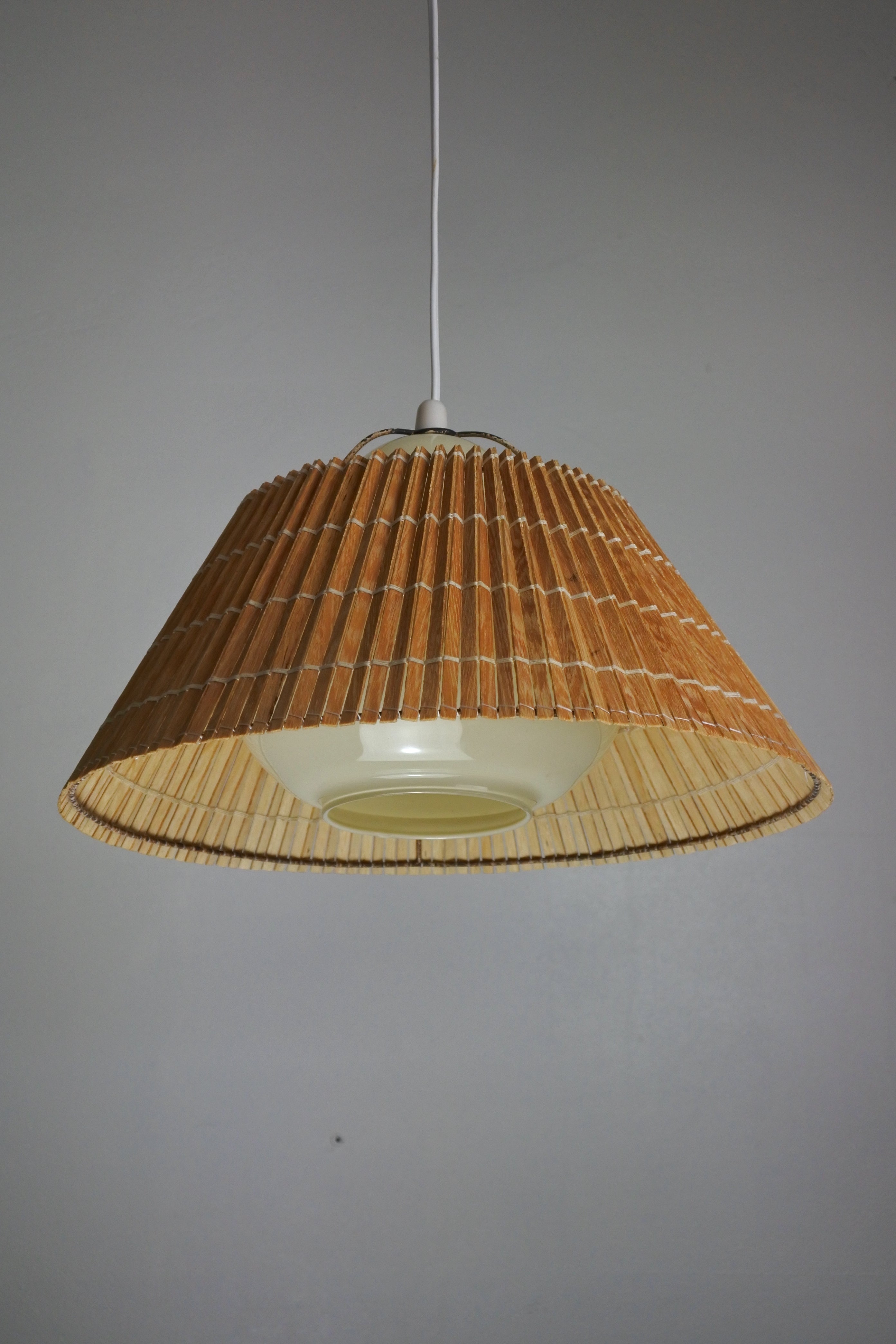 Pendant lamp by Lisa Johansson-Pape.
Manufactured by Orno in Finland in the 1950s.

Yellow opaline glass diffuser with a wooden shade.

Literature: Orno catalogues of the period.

Adjustable height. 70 cm as shown.

Original electrical