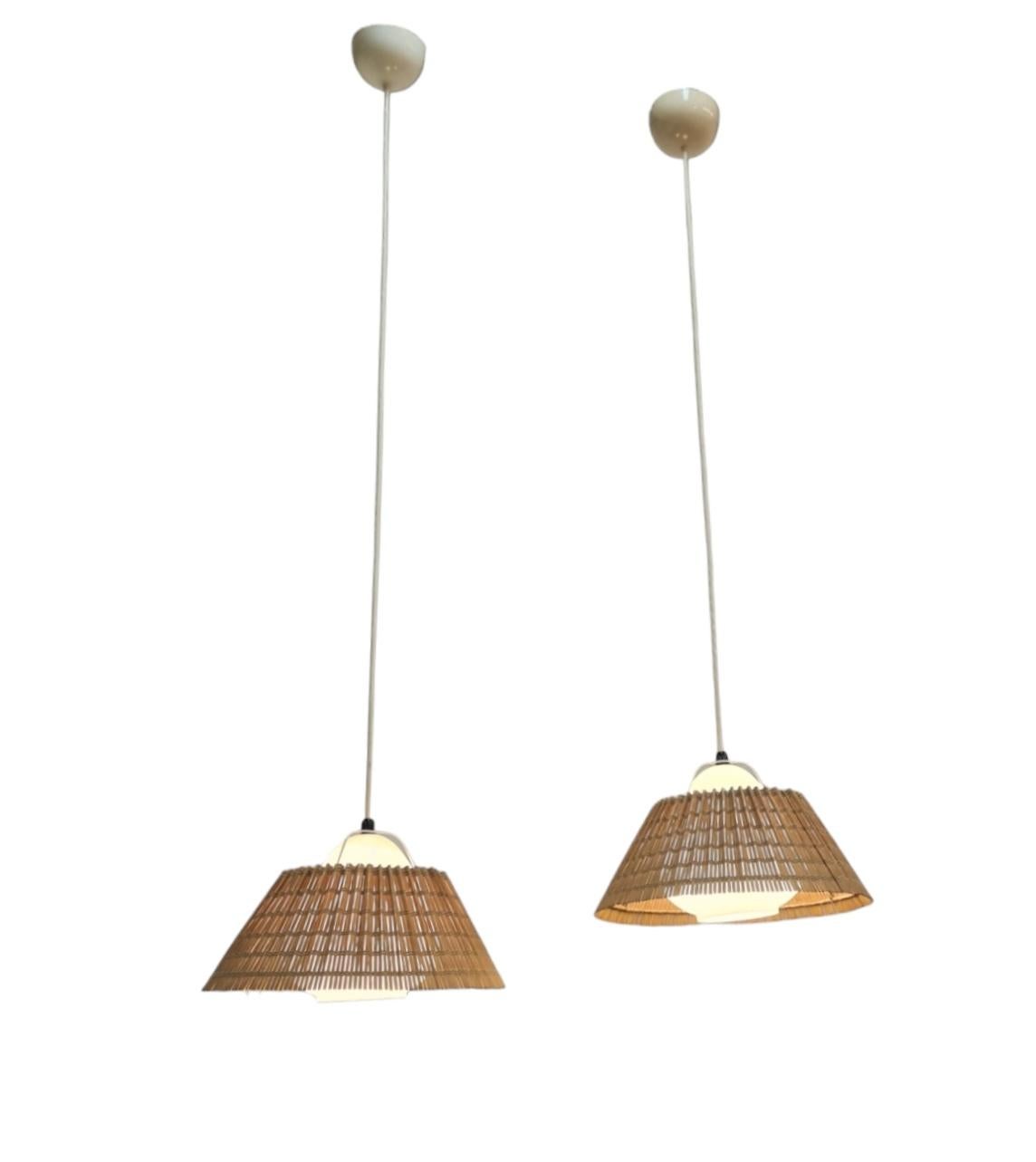 Ein schönes Paar Deckenlampen von Lisa Johansson-Papé aus den 1940er Jahren. Ein wunderschönes, organisches Design aus birnenförmigem, mundgeblasenem Opalglas mit dem originalen Rattan-Schirm. Die Lampen sind im Grunde frei hängend und werden durch