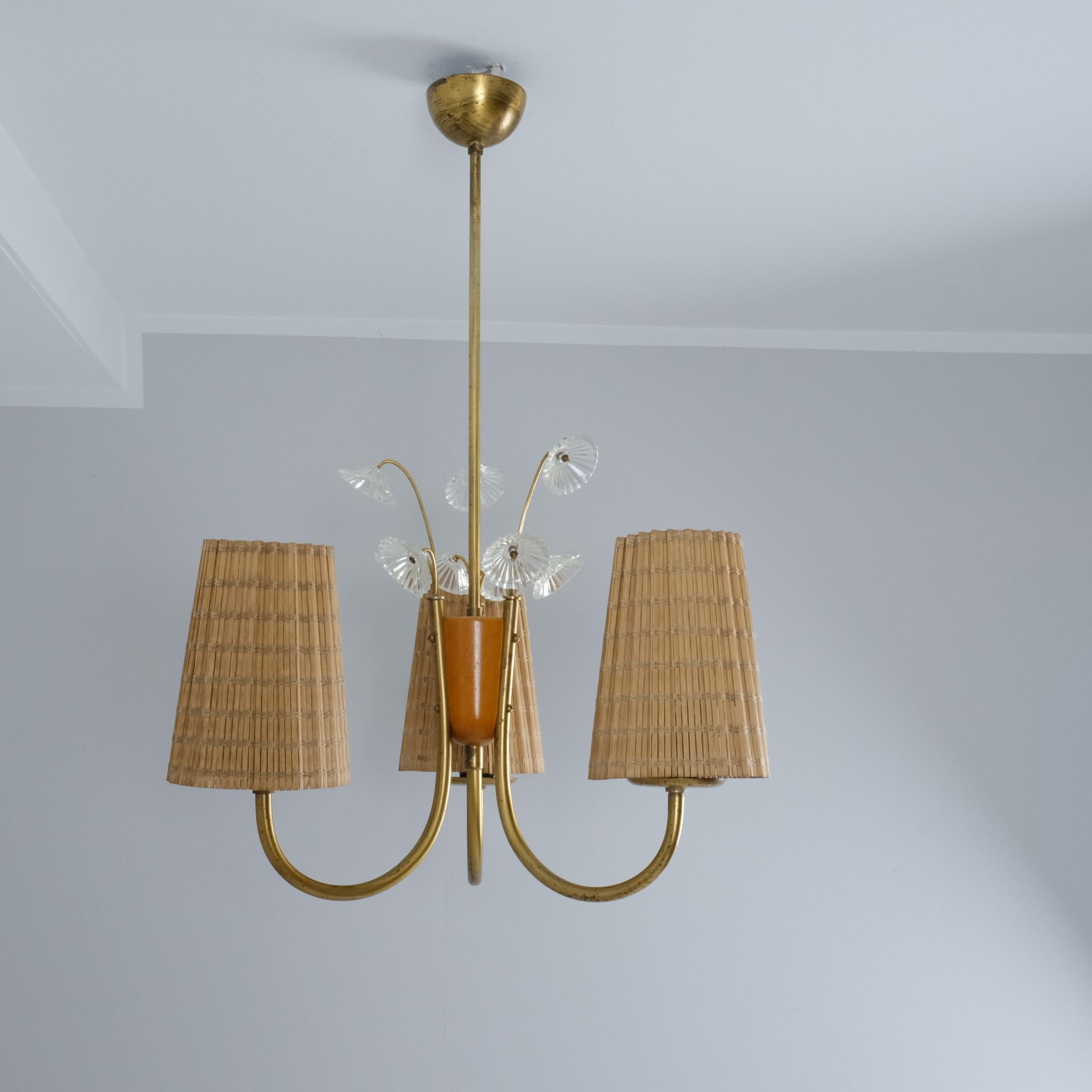 Un bellissimo e precoce pendente da soffitto di Lisa Johansson-Pape con un centro in legno di betulla e tre bracci in ottone e paralumi in rattan. Al centro sono presenti anche decorazioni floreali in vetro rimovibili.

Il ciondolo è una bellezza